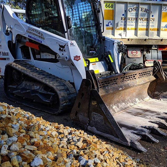 White Excavator Beside Stones — Earthmoving Services  in Eungai Creek, NSW