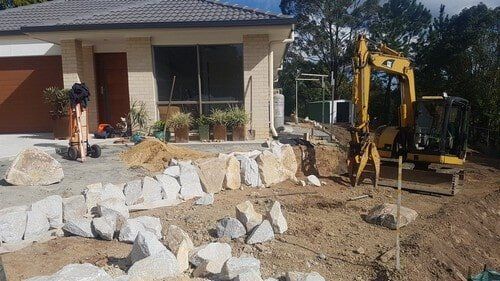 Yellow Excavator Beside House — Earthmoving Services  in Eungai Creek, NSW