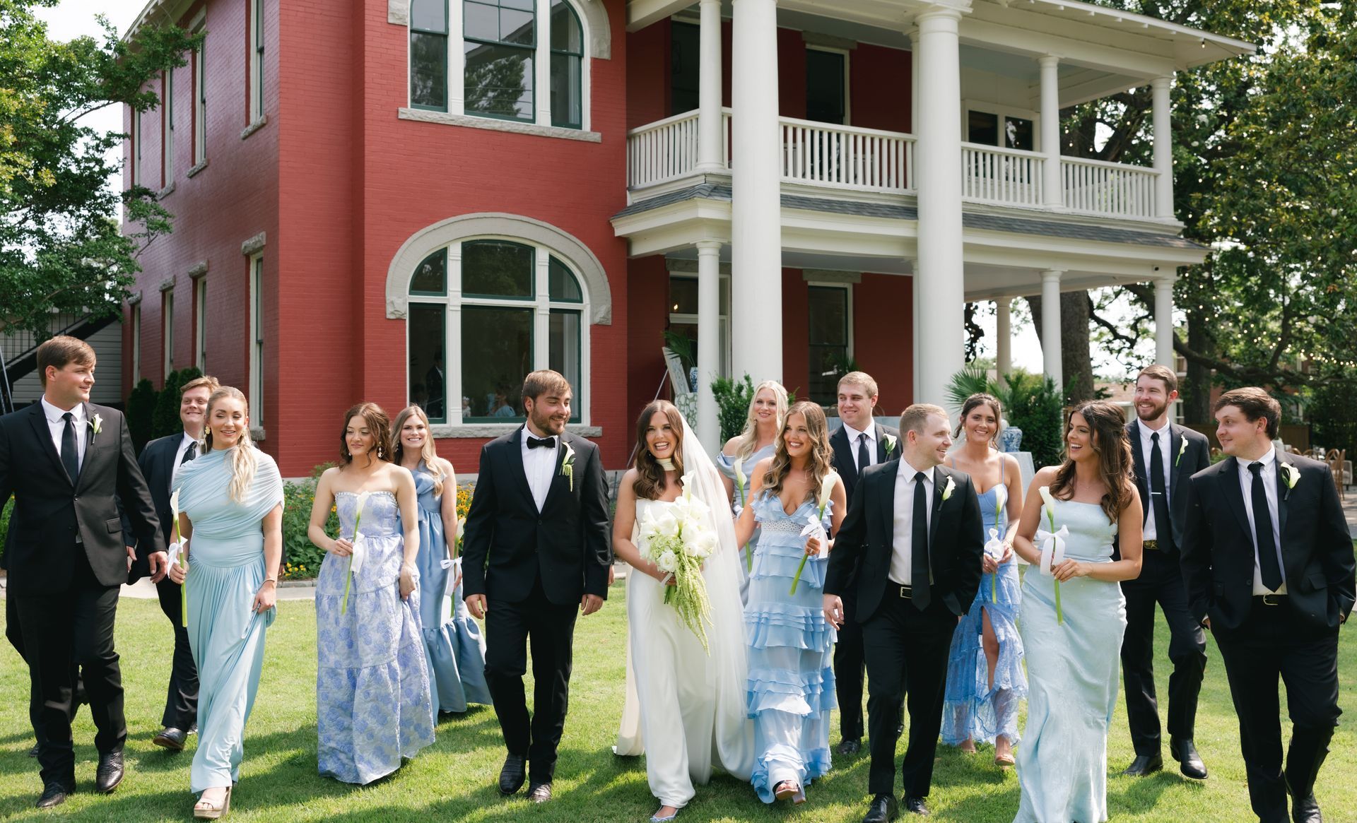 Married couple embracing on a sunny summer day in the historic Argenta district, surrounded by charming architecture and lush greenery.