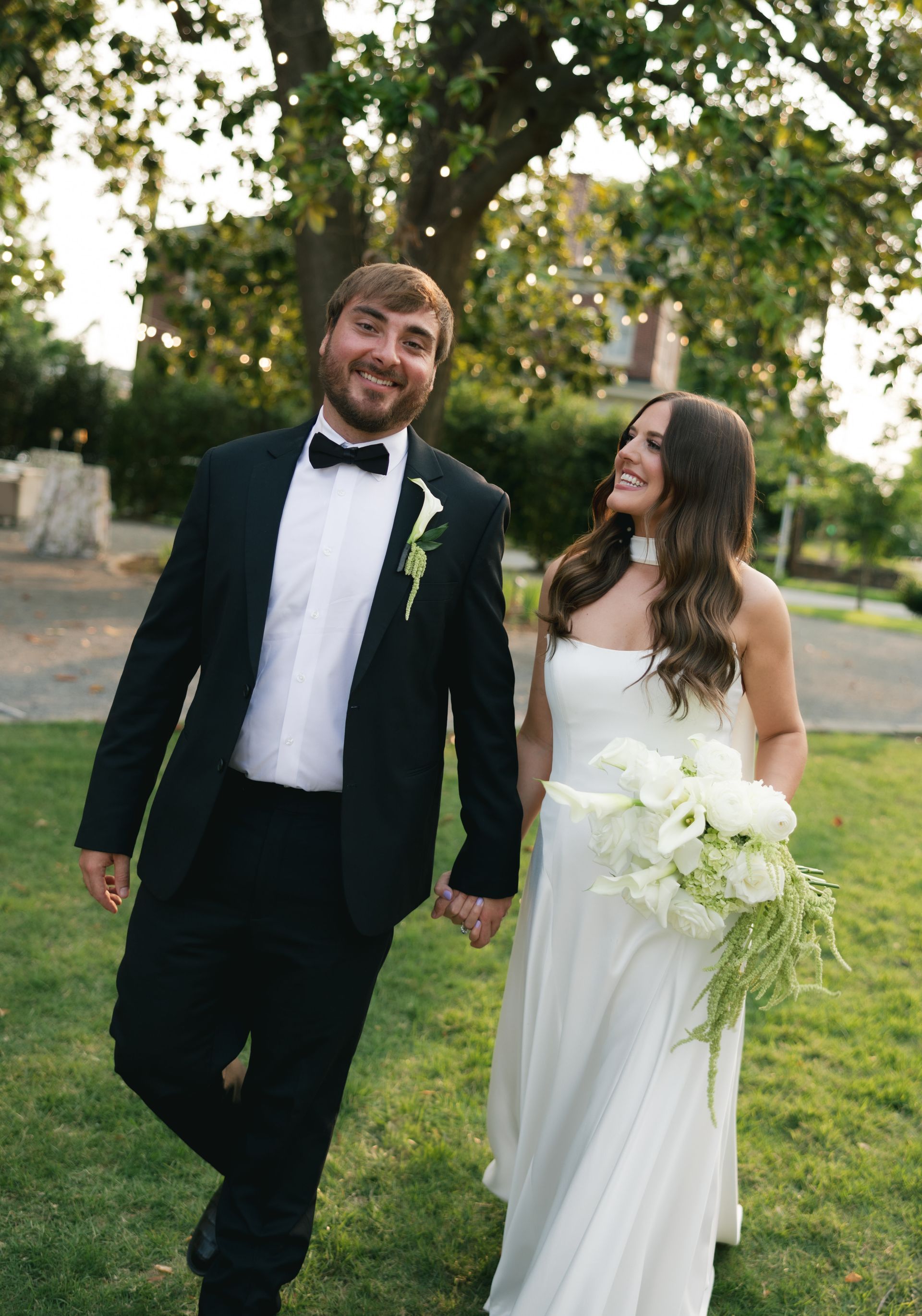 Married couple embracing on a sunny summer day in the historic Argenta district, surrounded by charming architecture and lush greenery.