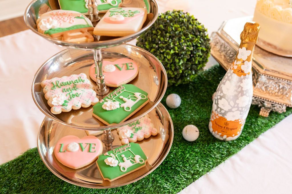 A bottle of champagne and a tray of cookies on a table.