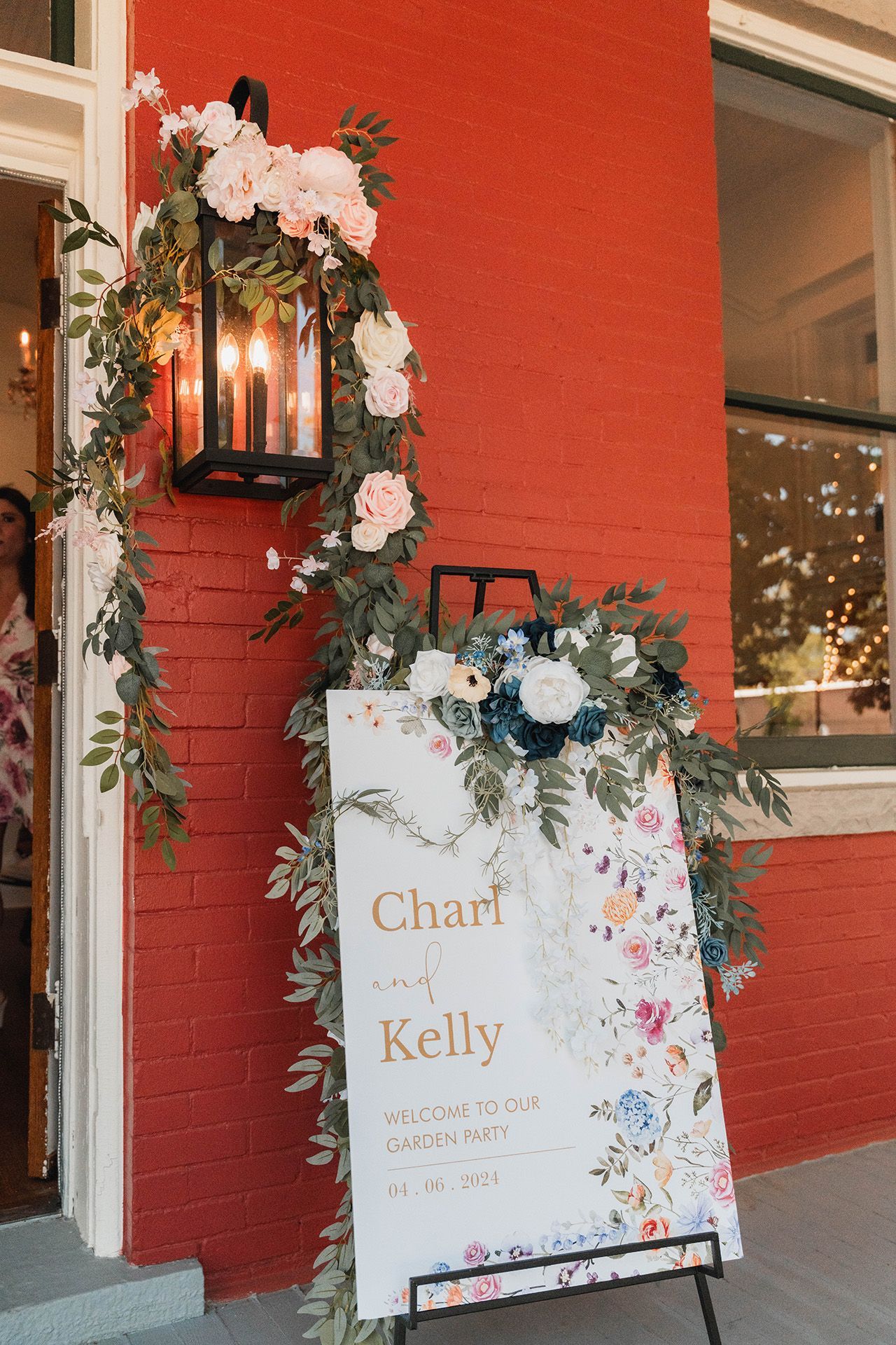 A sign for a wedding is hanging on a red brick wall.