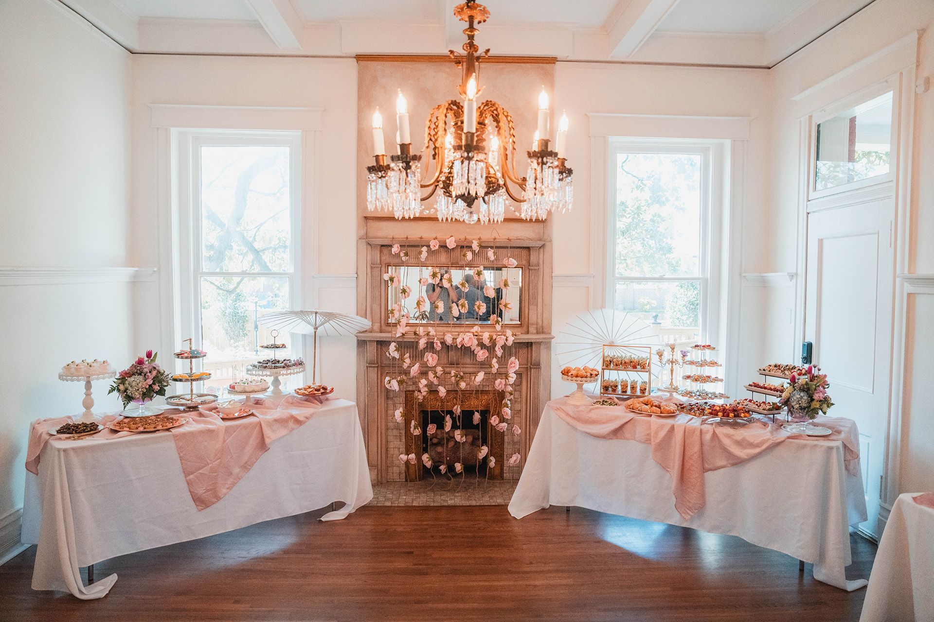A room filled with tables and a fireplace with a chandelier.