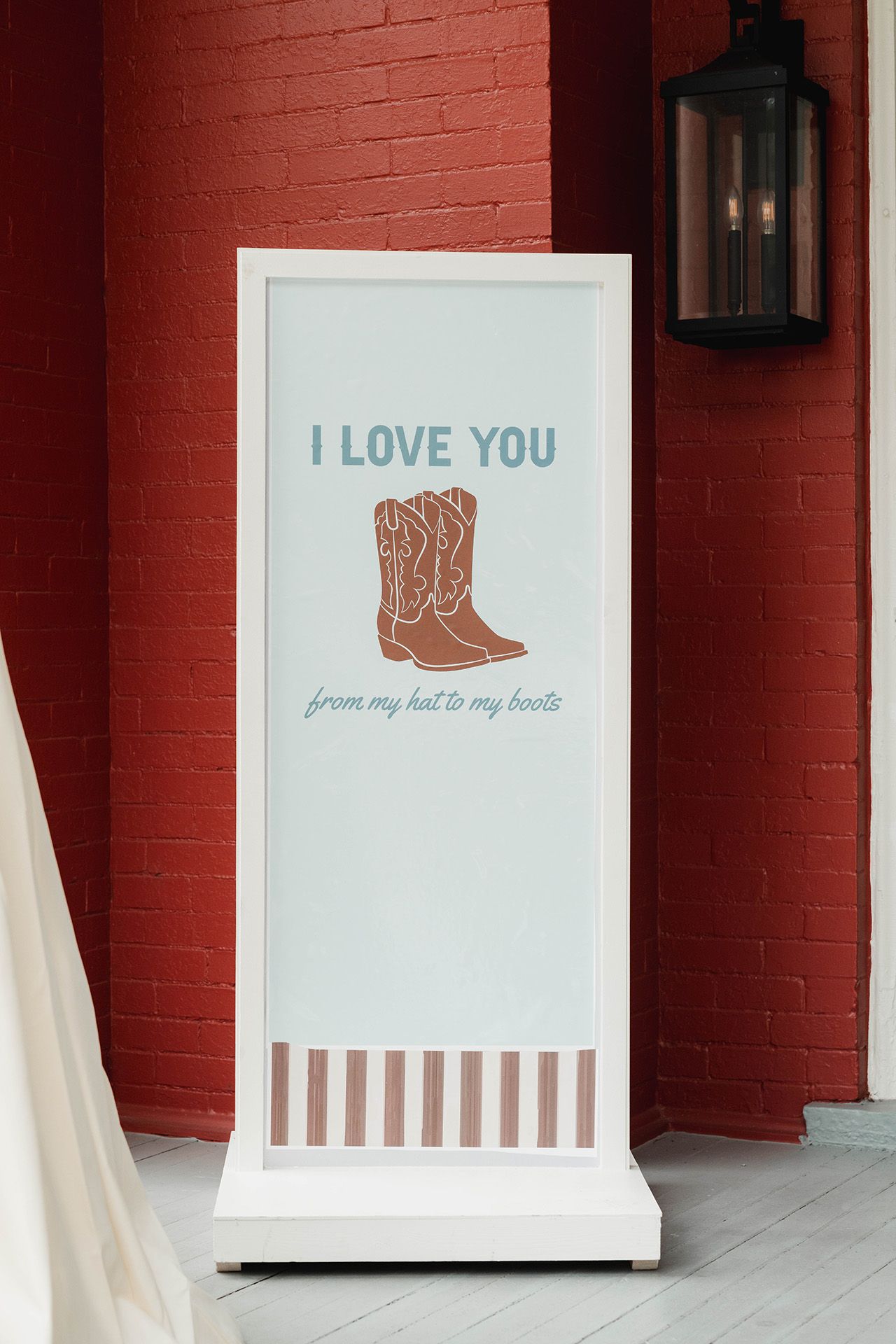 A sign that says `` i love you '' with a pair of cowboy boots on it.