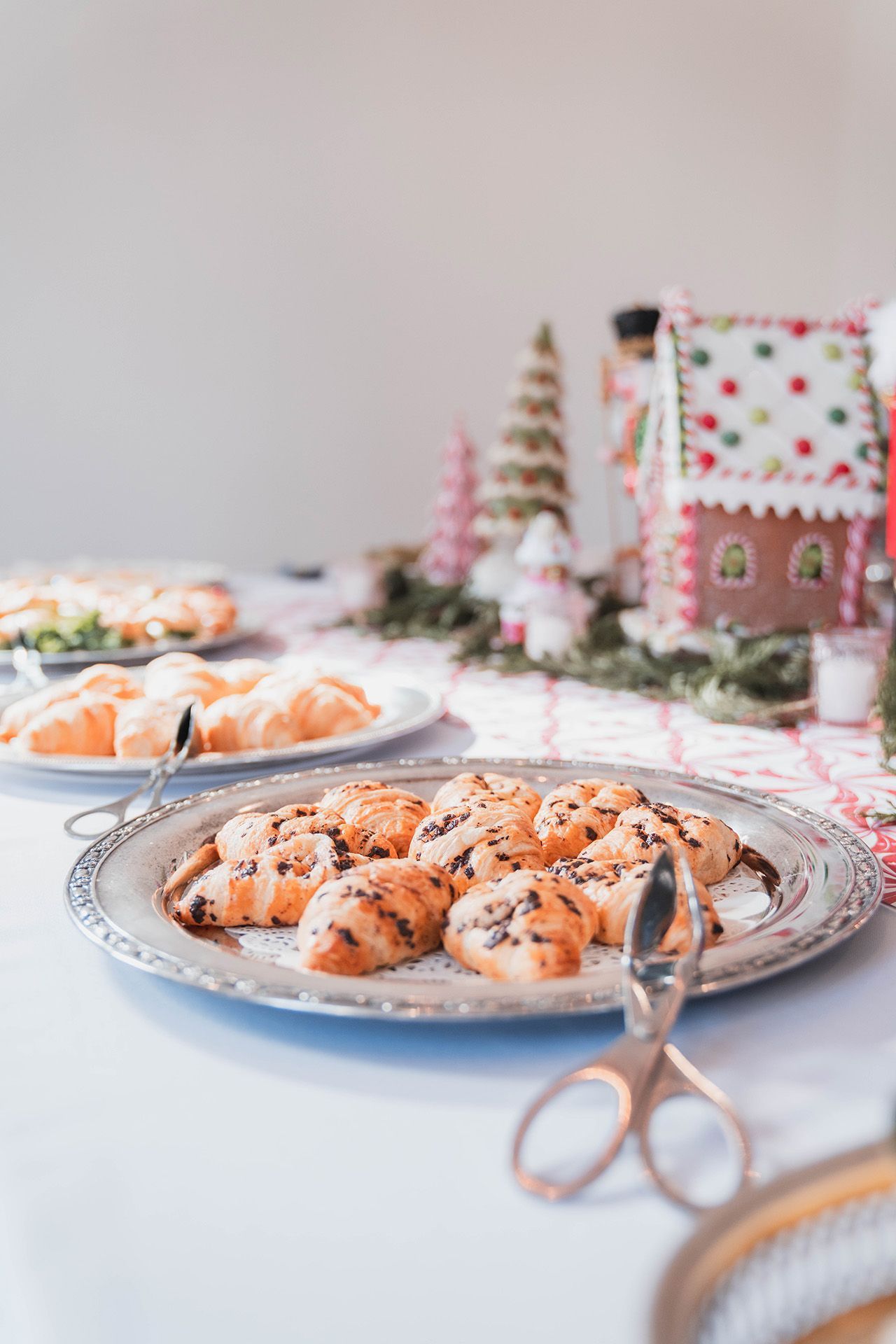 A silver plate topped with cookies and scissors on a table.
