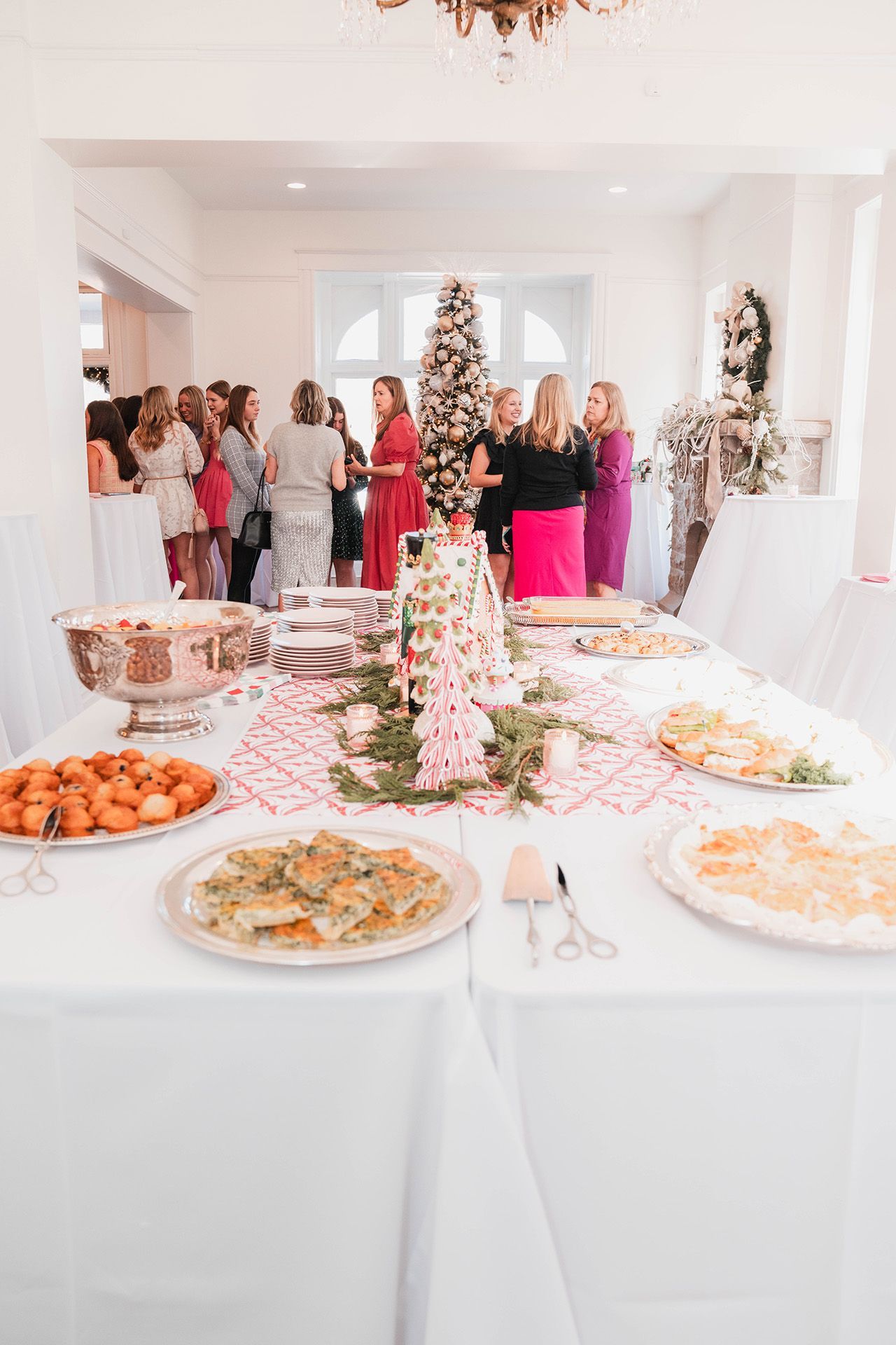 A table with plates of food and a christmas tree on it.