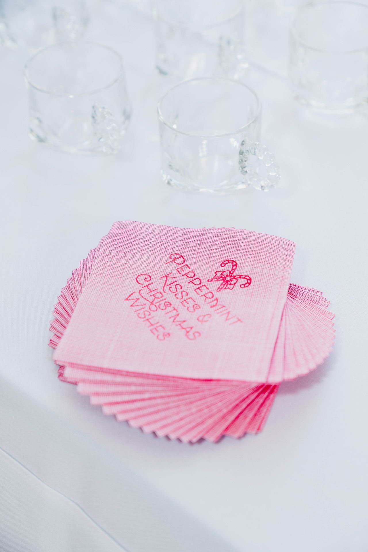 A stack of pink napkins sitting on top of a white table.