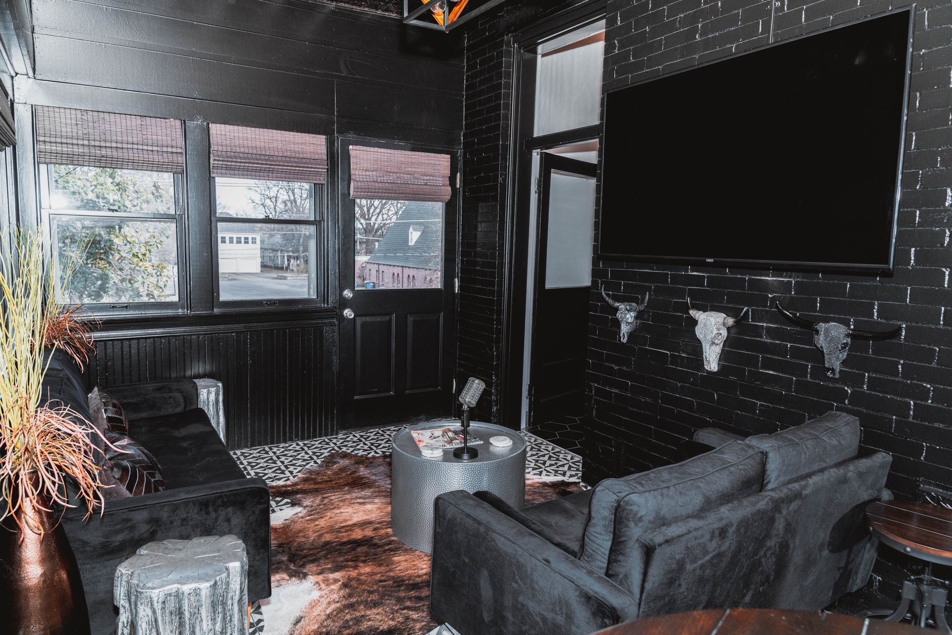 A living room with a couch , chair , table and television.