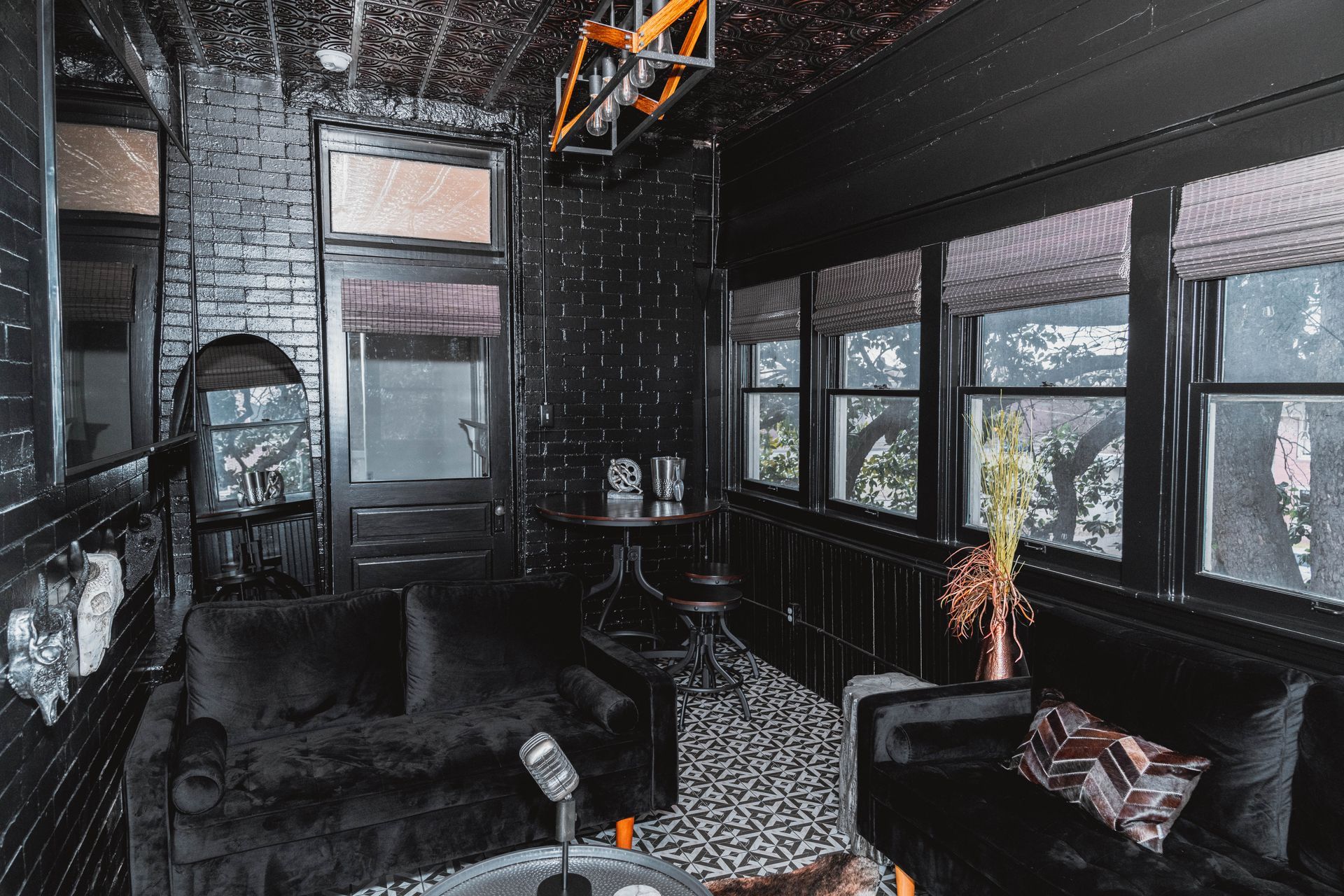 A living room with black furniture and a microphone.