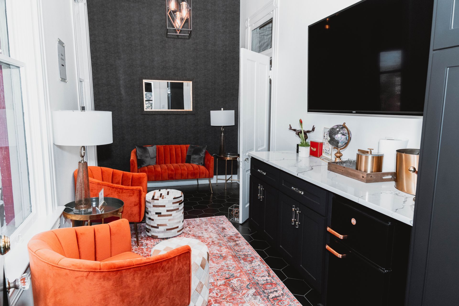 A living room with a couch , chairs , and a flat screen tv.