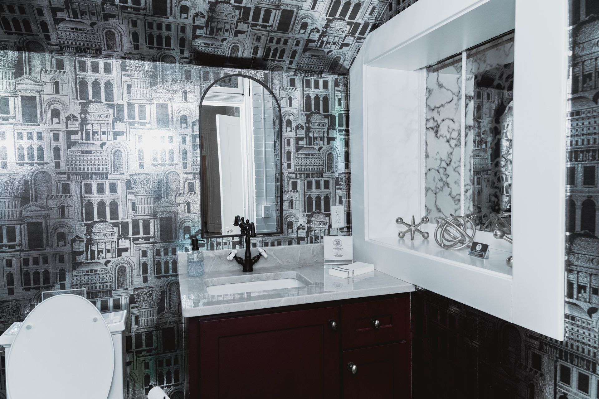 A bathroom with a sink , mirror and toilet.