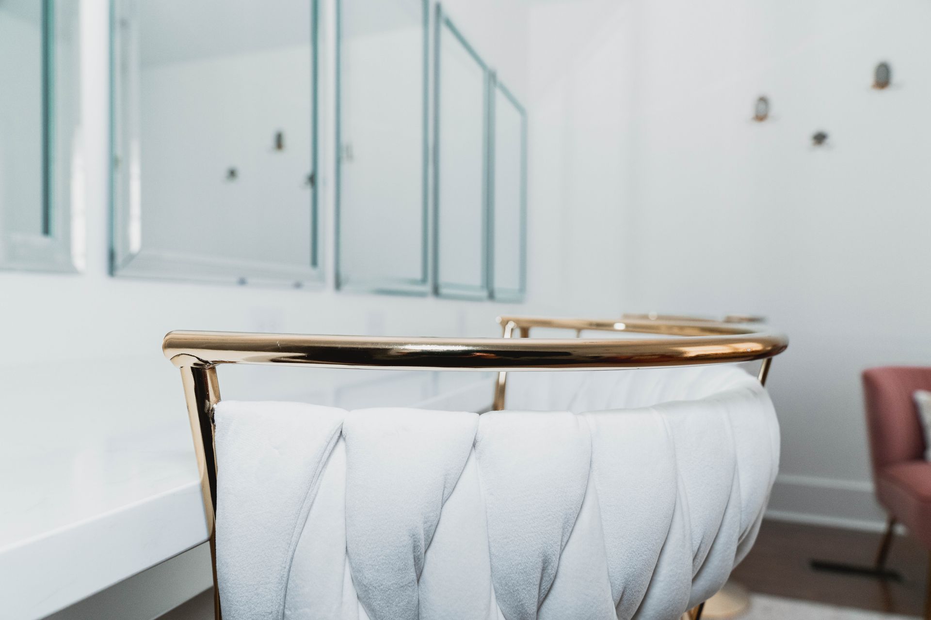 A white chair with a gold frame is sitting in a room.