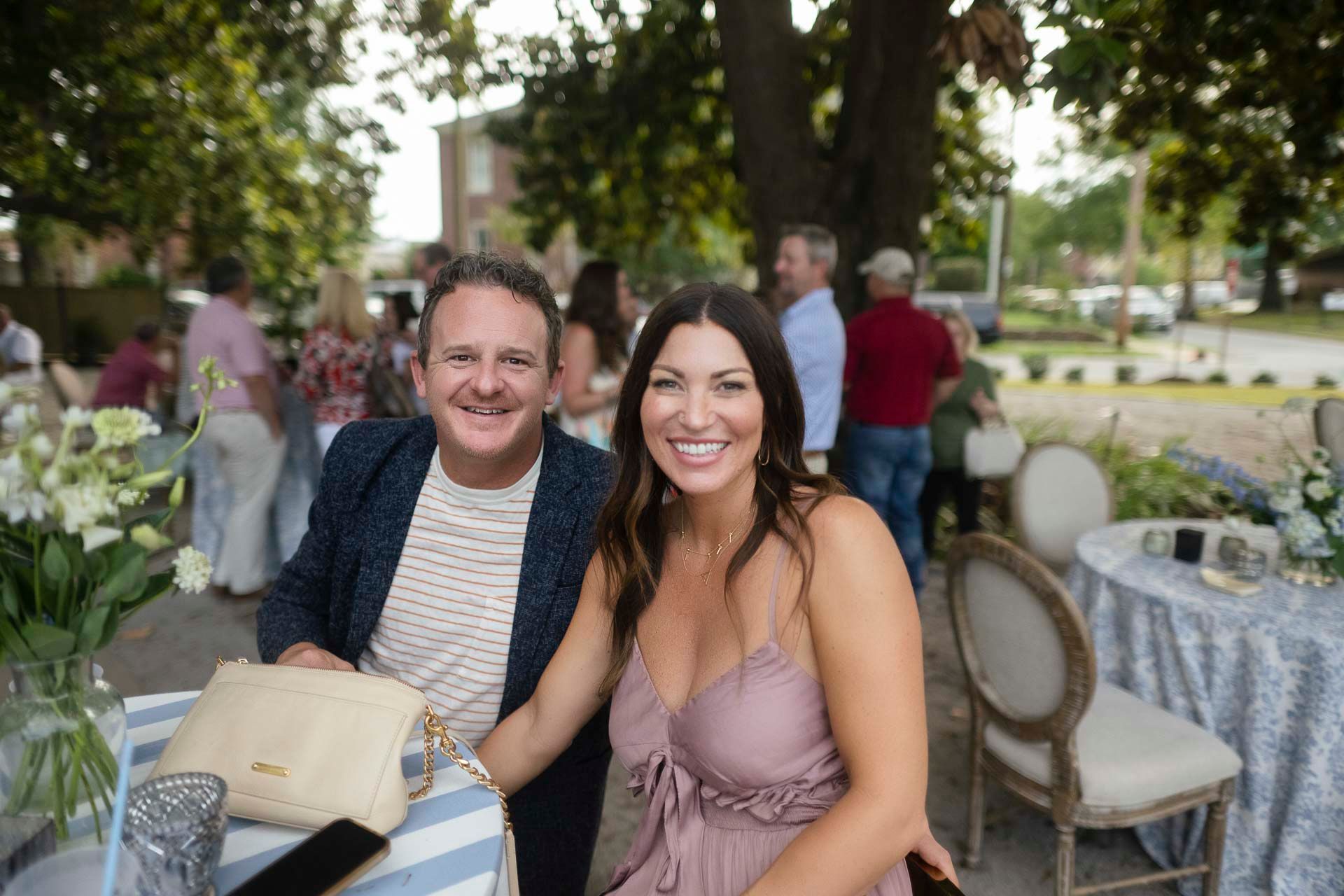 A man and a woman are posing for a picture while sitting at a table.
