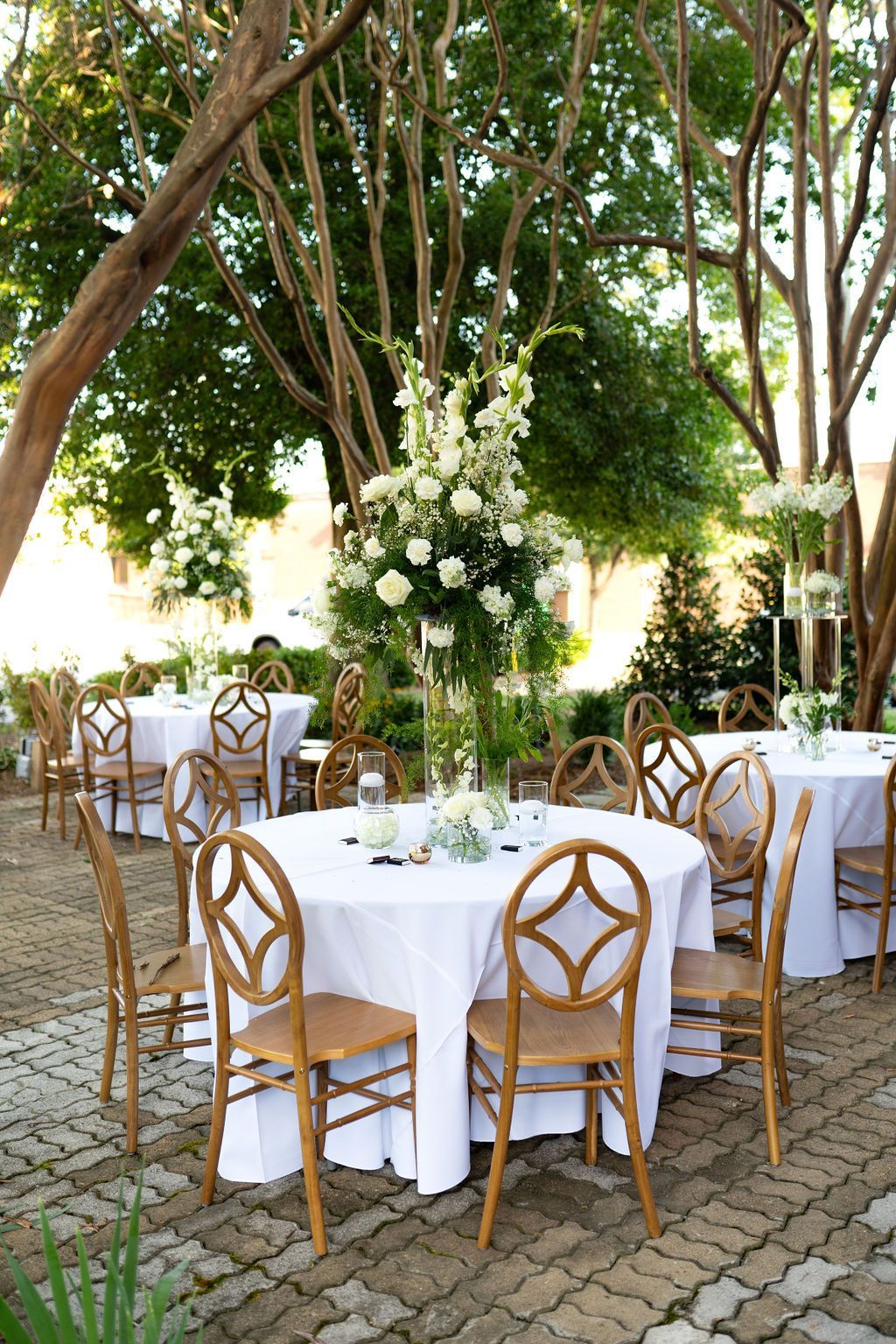 A patio with tables and chairs set up for a wedding reception.