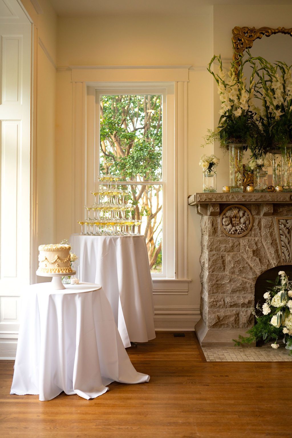 A room with two tables and a fireplace with a cake on it.
