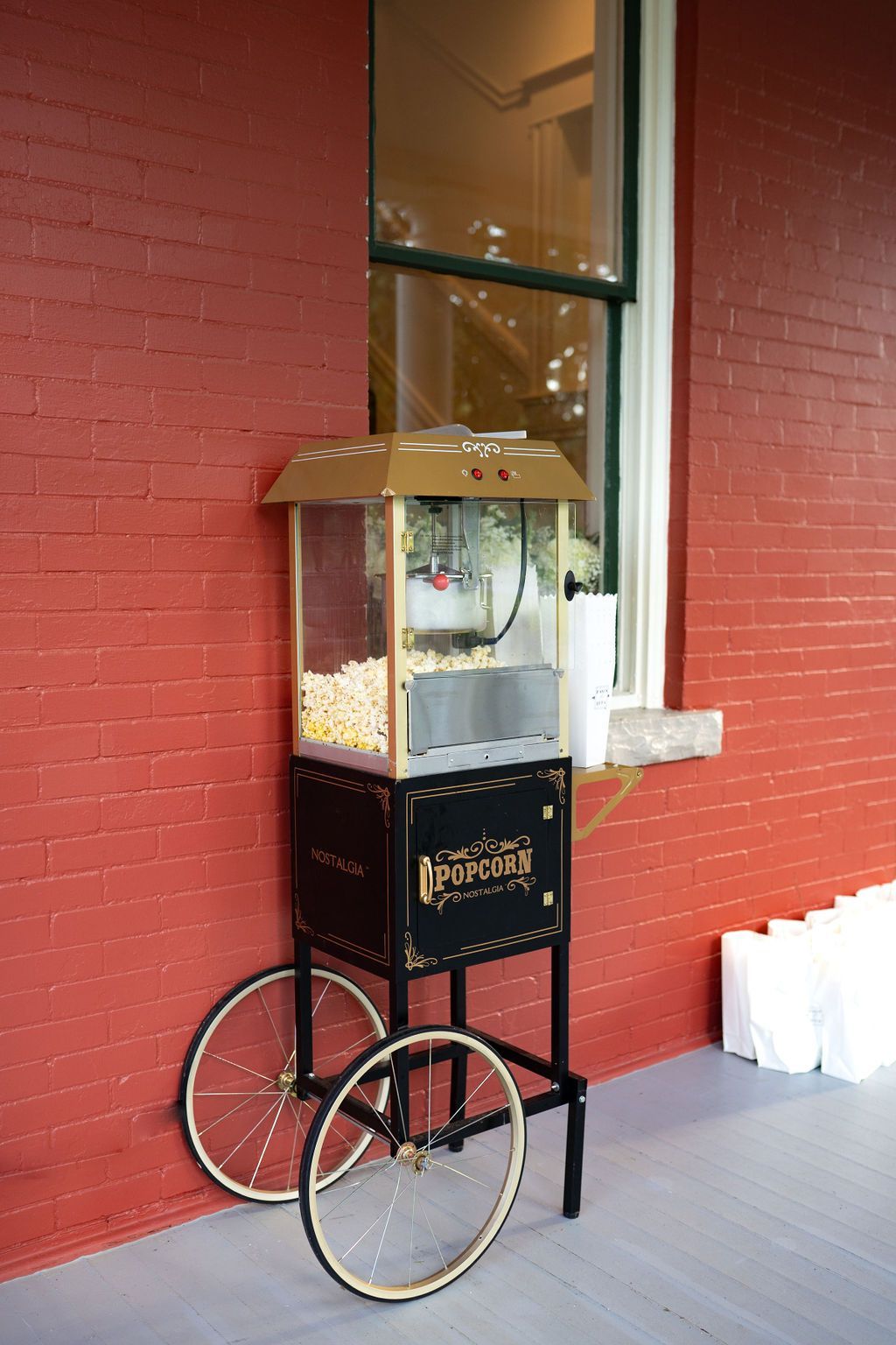 A popcorn machine on wheels is sitting in front of E.O. Manees House