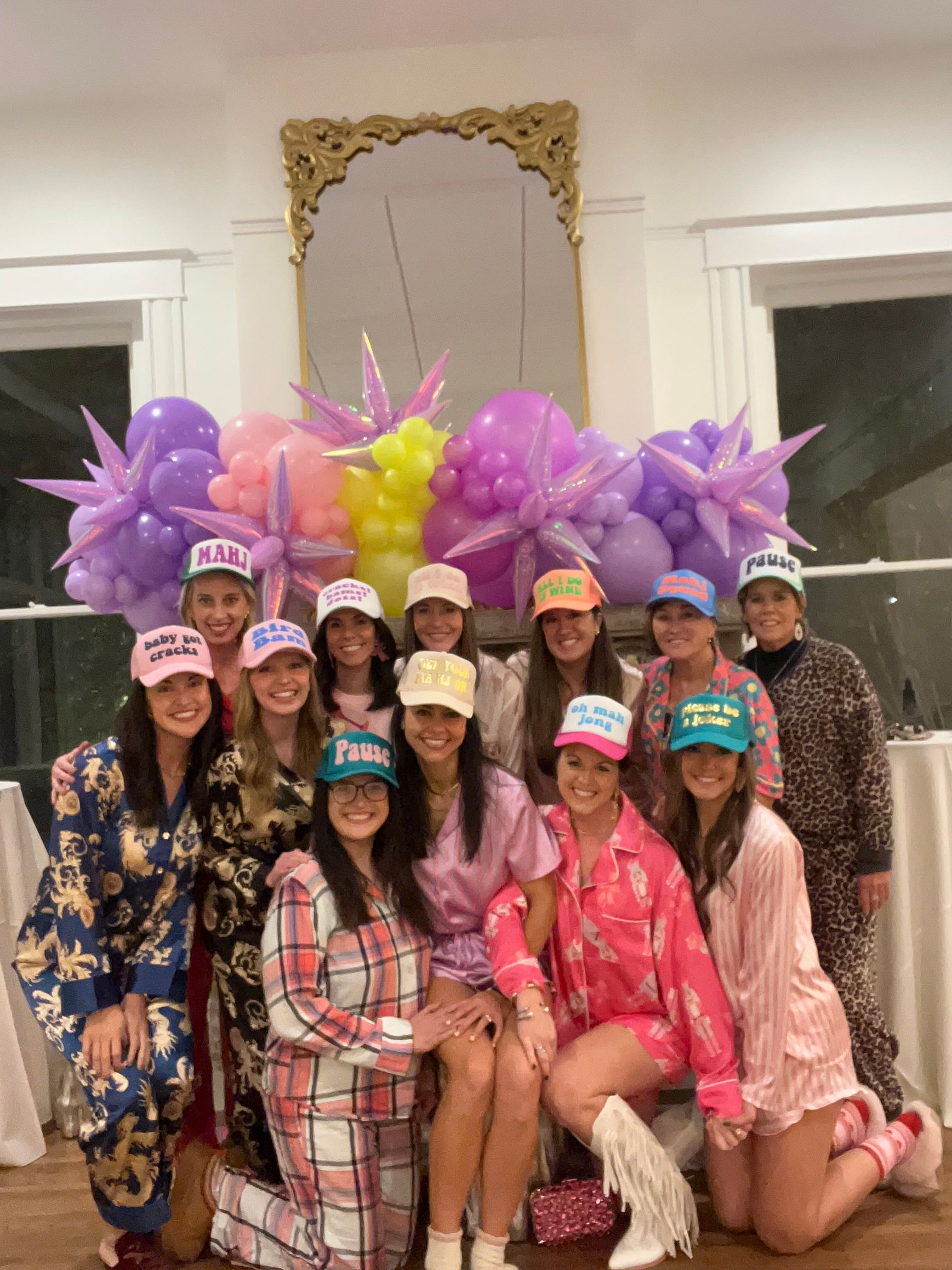 A group of women are posing for a picture in front of balloons at EO Manees House in North Little Rock, AR