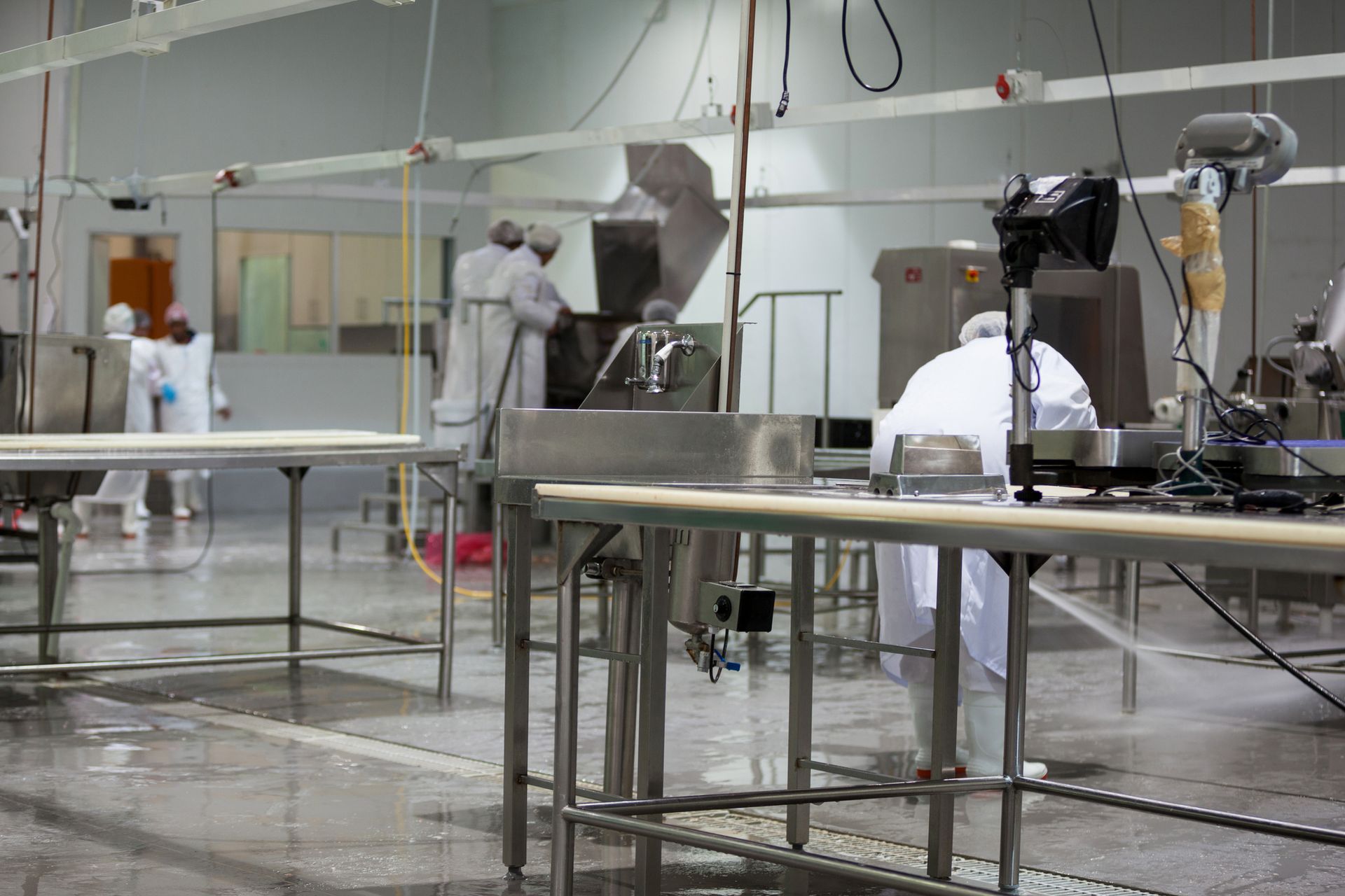 A group of people are working in a clean room in a factory.