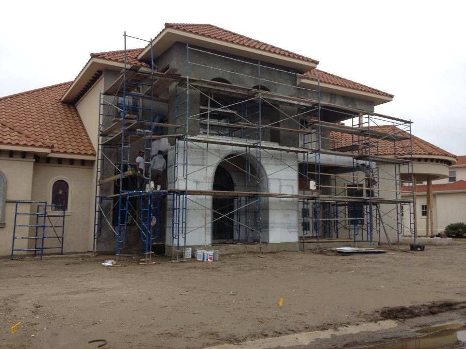 A man wearing a hard hat and goggles is standing in a room.