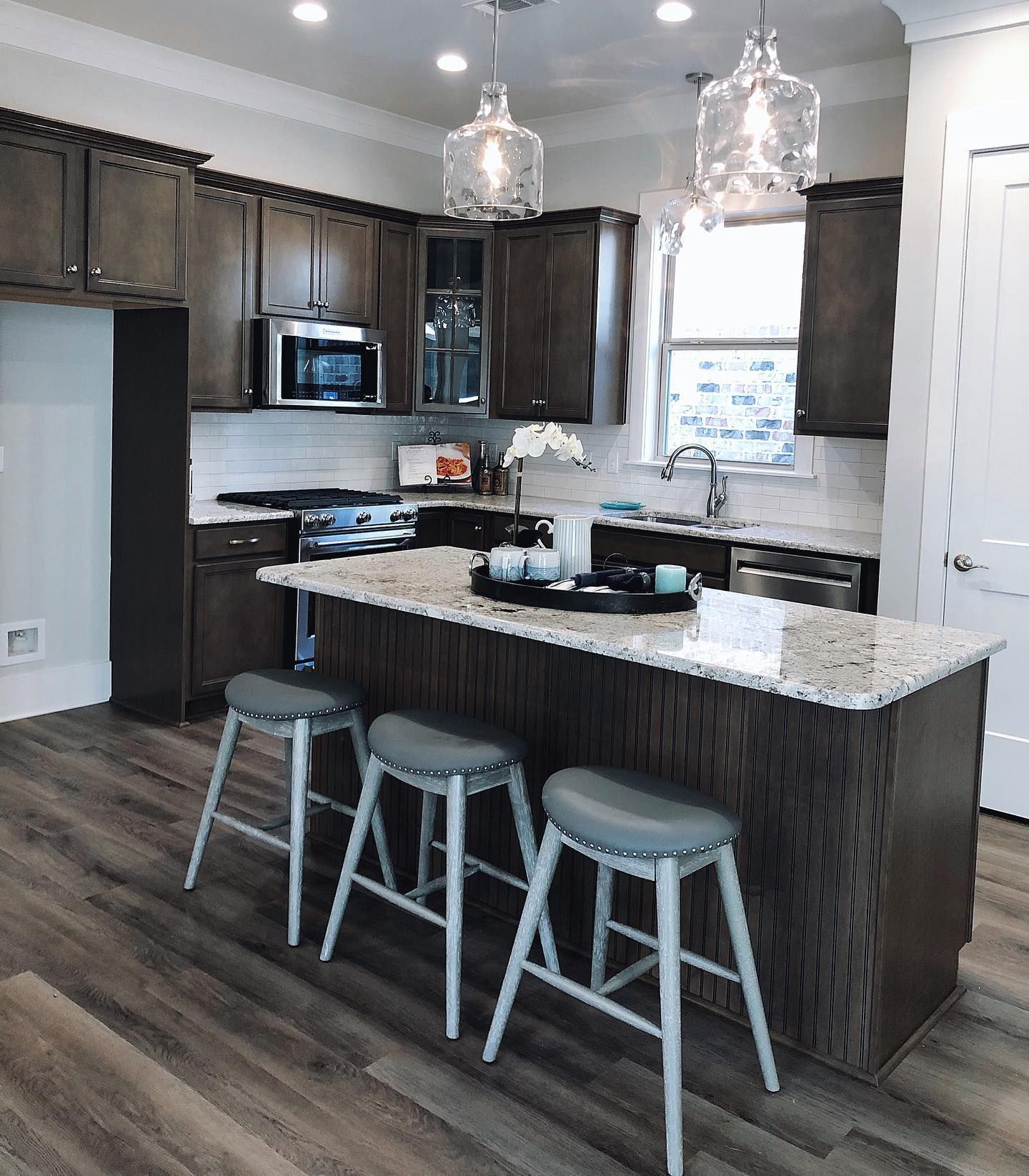A yellow excavator is sitting on top of a pile of gravel.