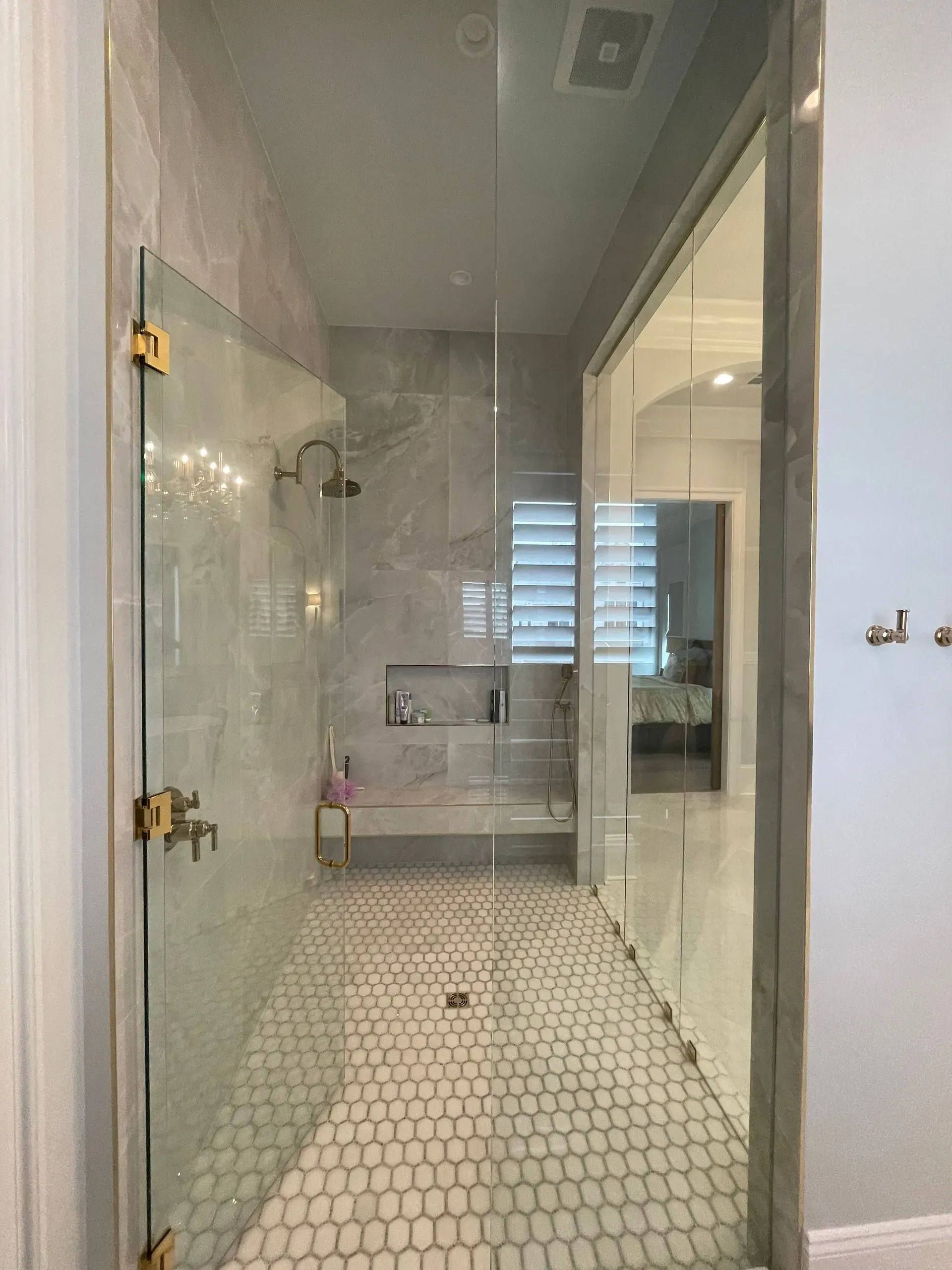 A bathroom with a walk in shower with a glass door.