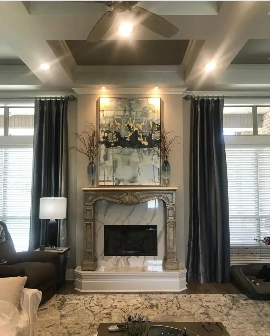 A living room with a fireplace and a ceiling fan