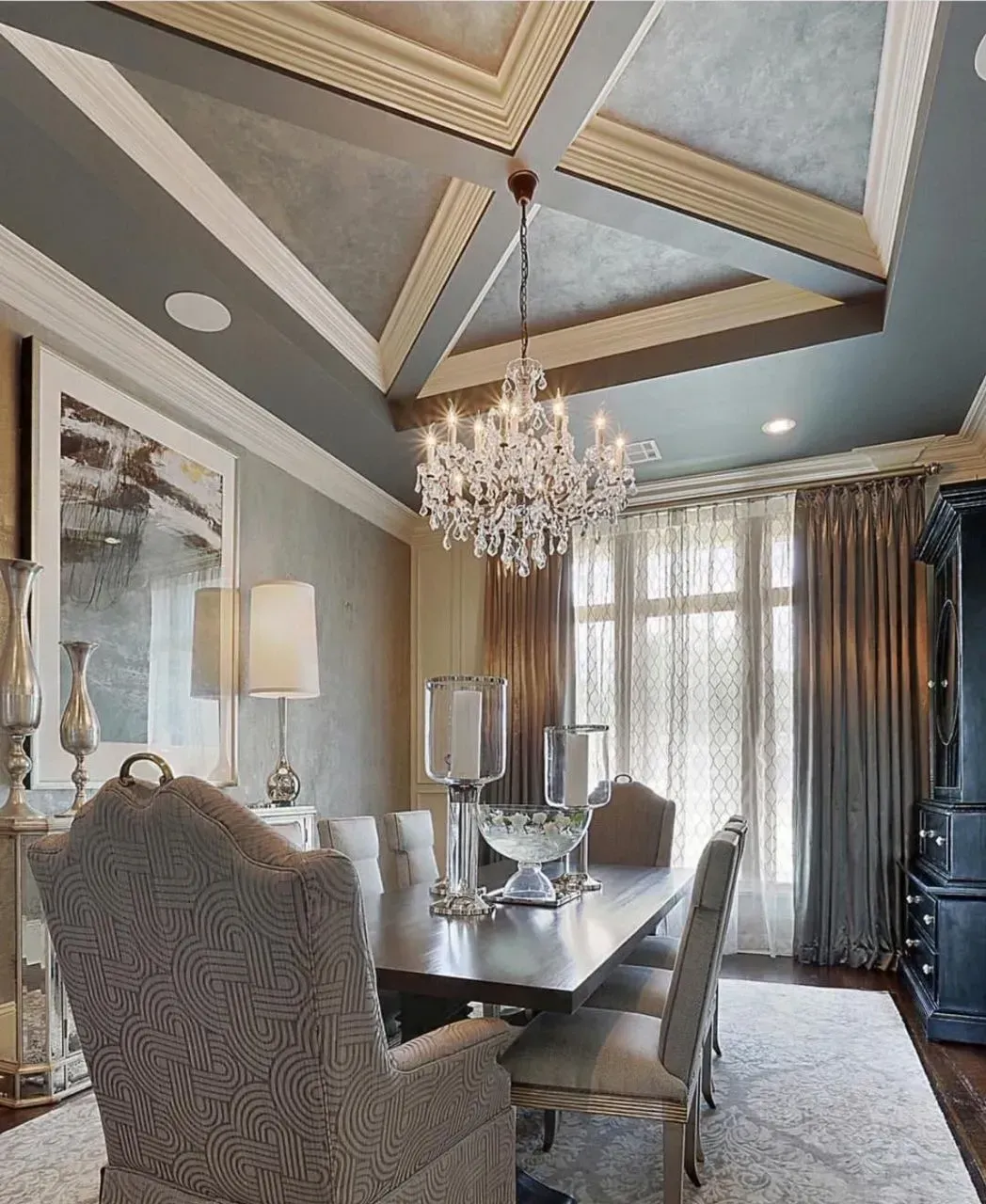 A dining room with a table and chairs and a chandelier hanging from the ceiling