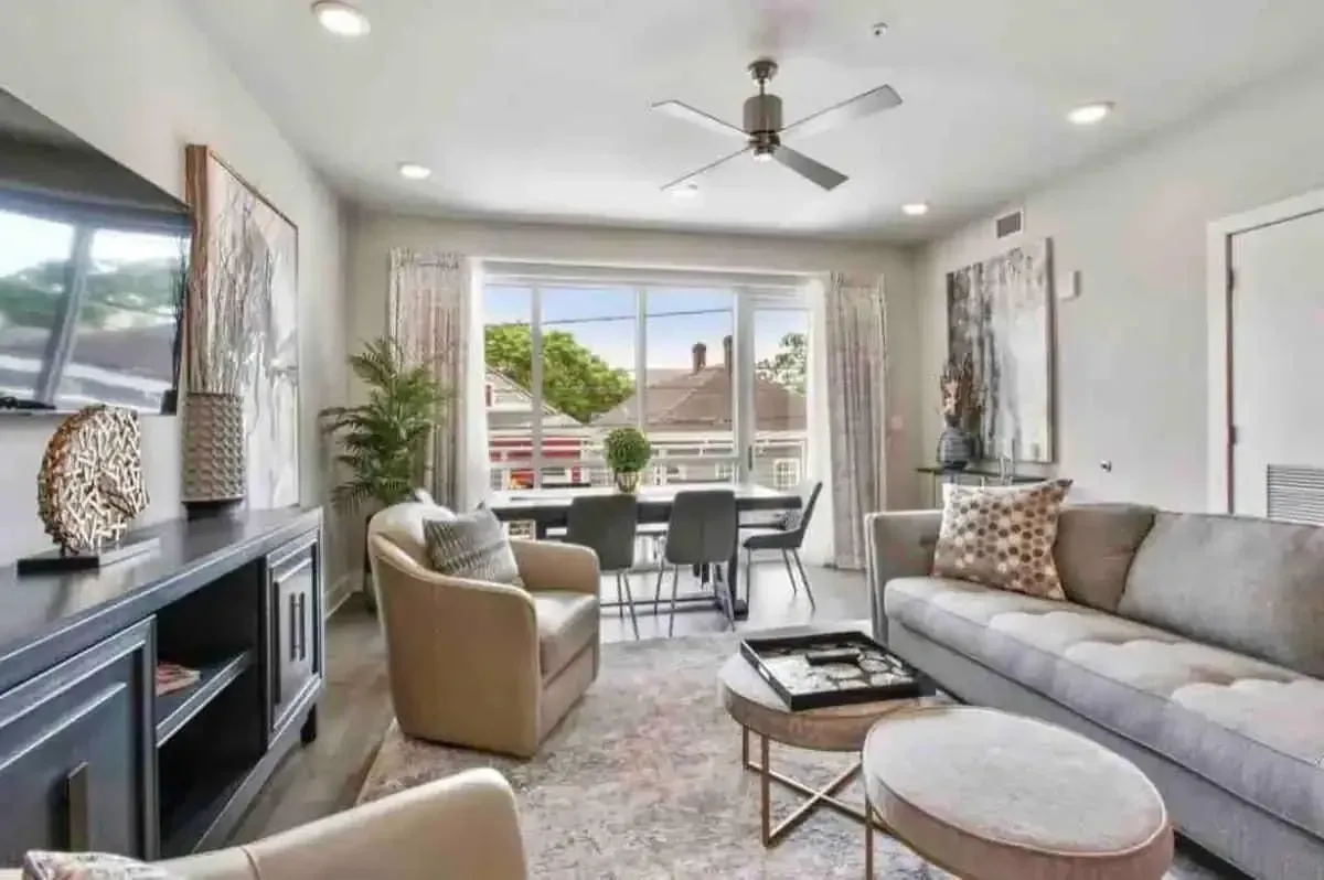 A living room with a couch , chairs , table and television.