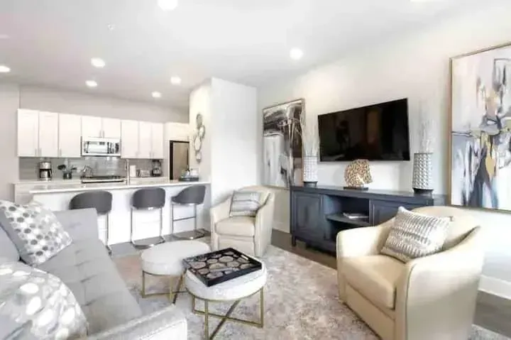 A living room with a couch , chair , table and television.