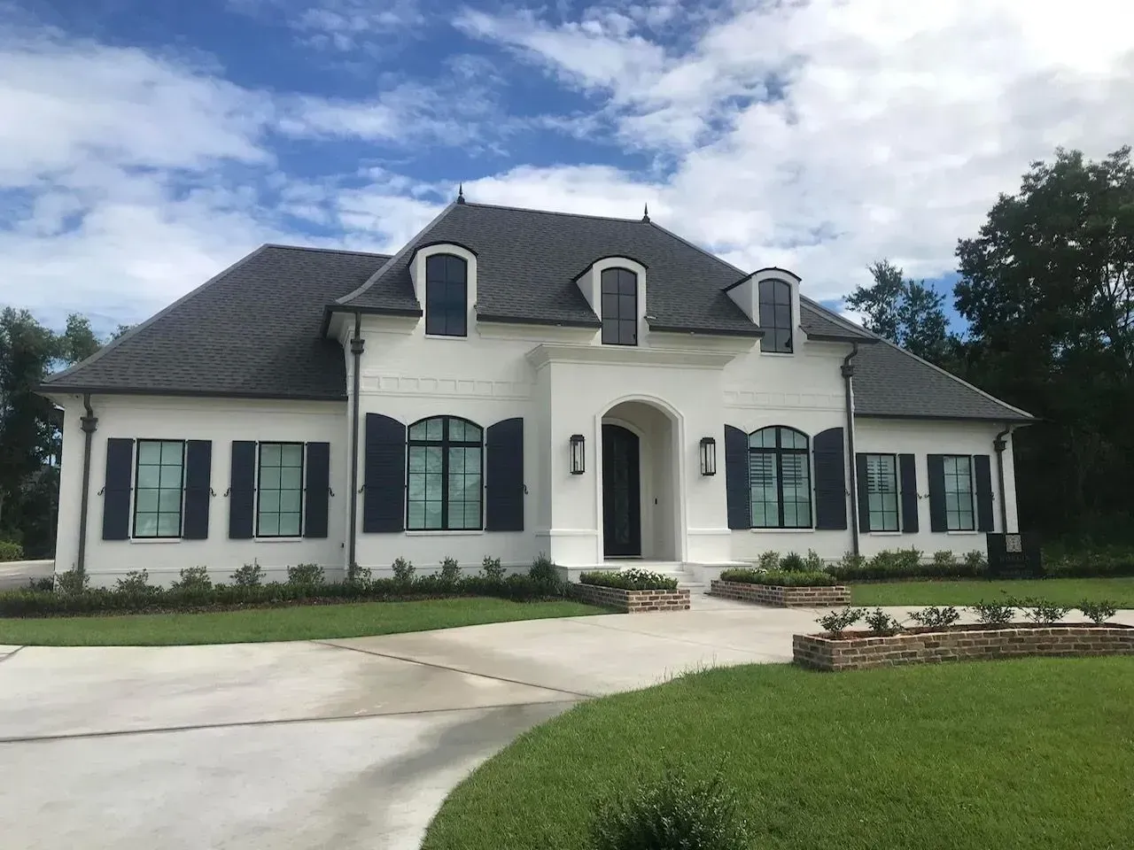 A large white house with black shutters on the windows
