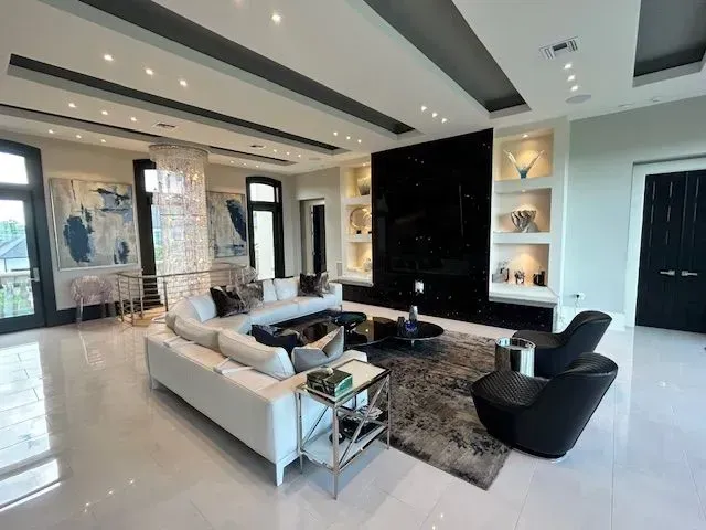 A living room with a couch , chairs , and a fireplace.