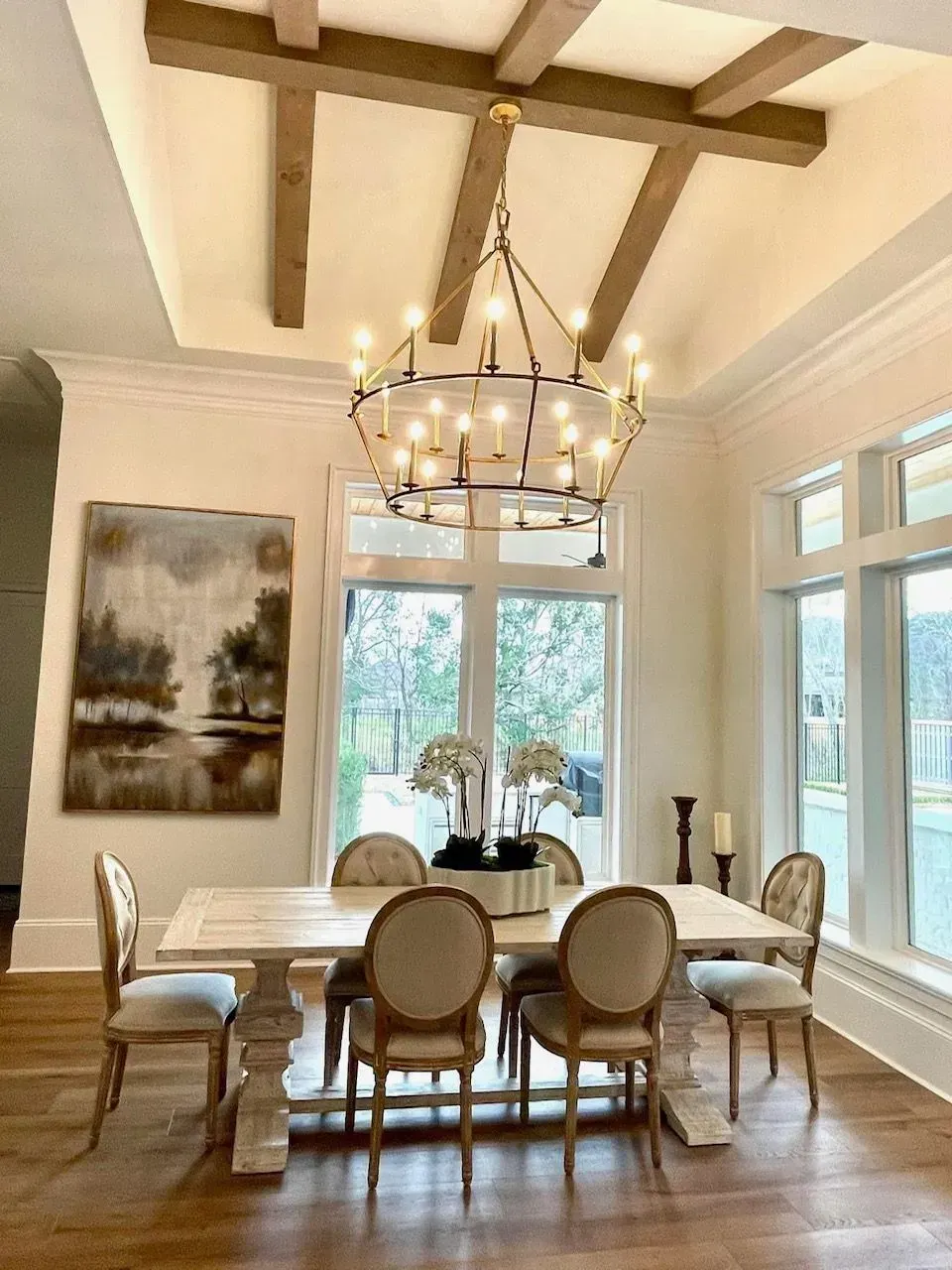 A dining room with a table and chairs and a chandelier hanging from the ceiling.