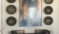 A painting is hanging on a wall next to a couch.