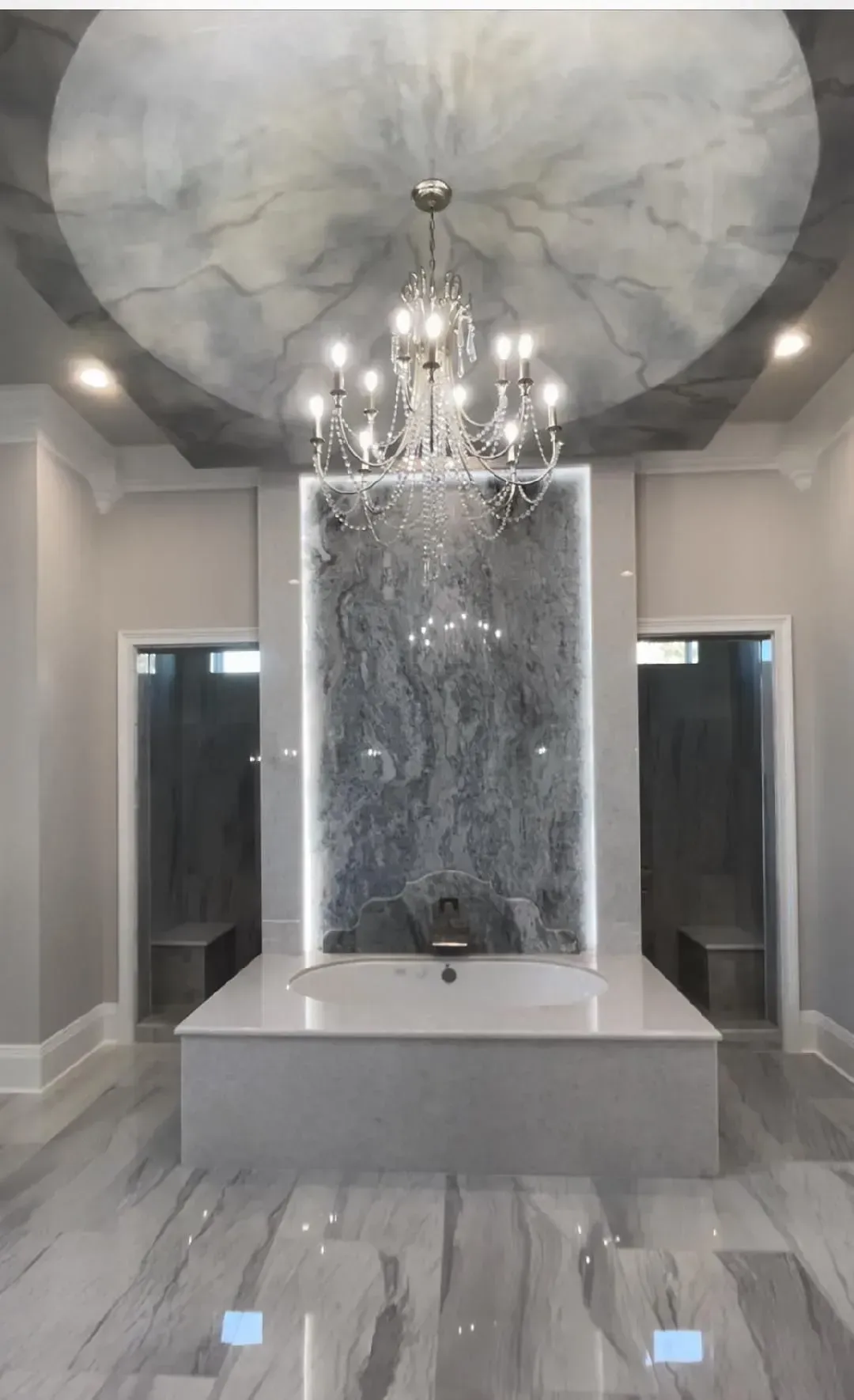 A bathroom with a large tub and a chandelier hanging from the ceiling.