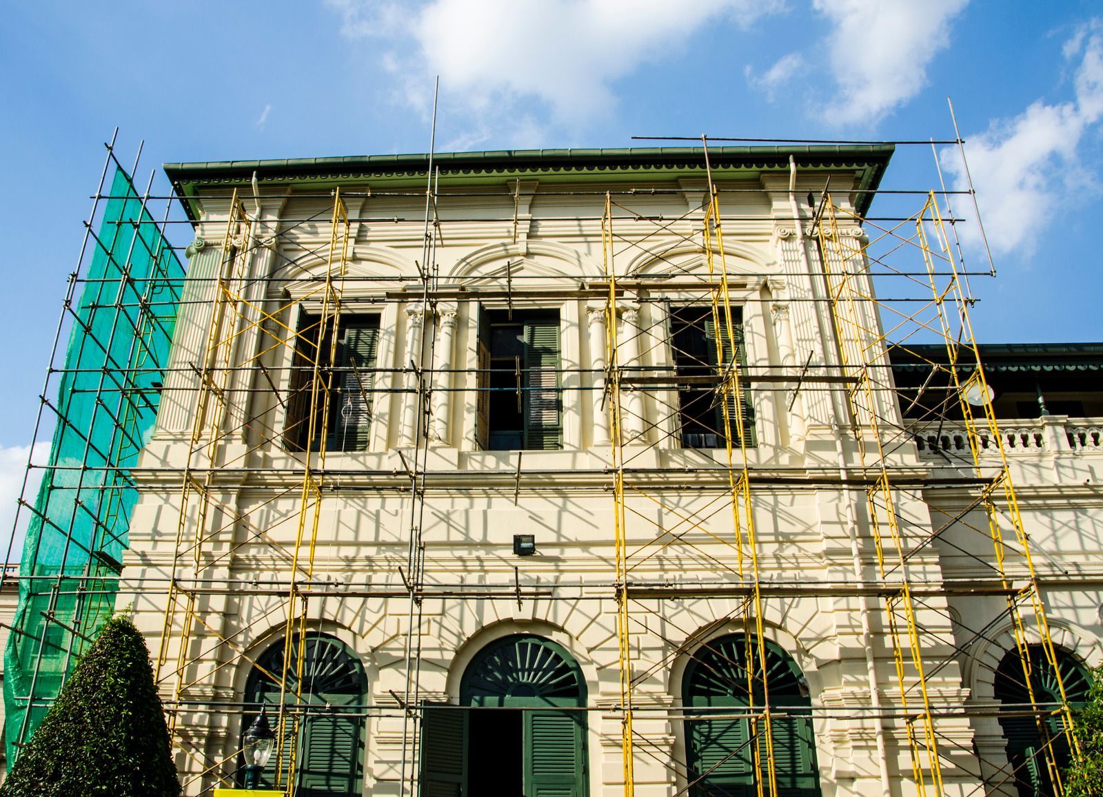 A yellow excavator is sitting on top of a pile of gravel.