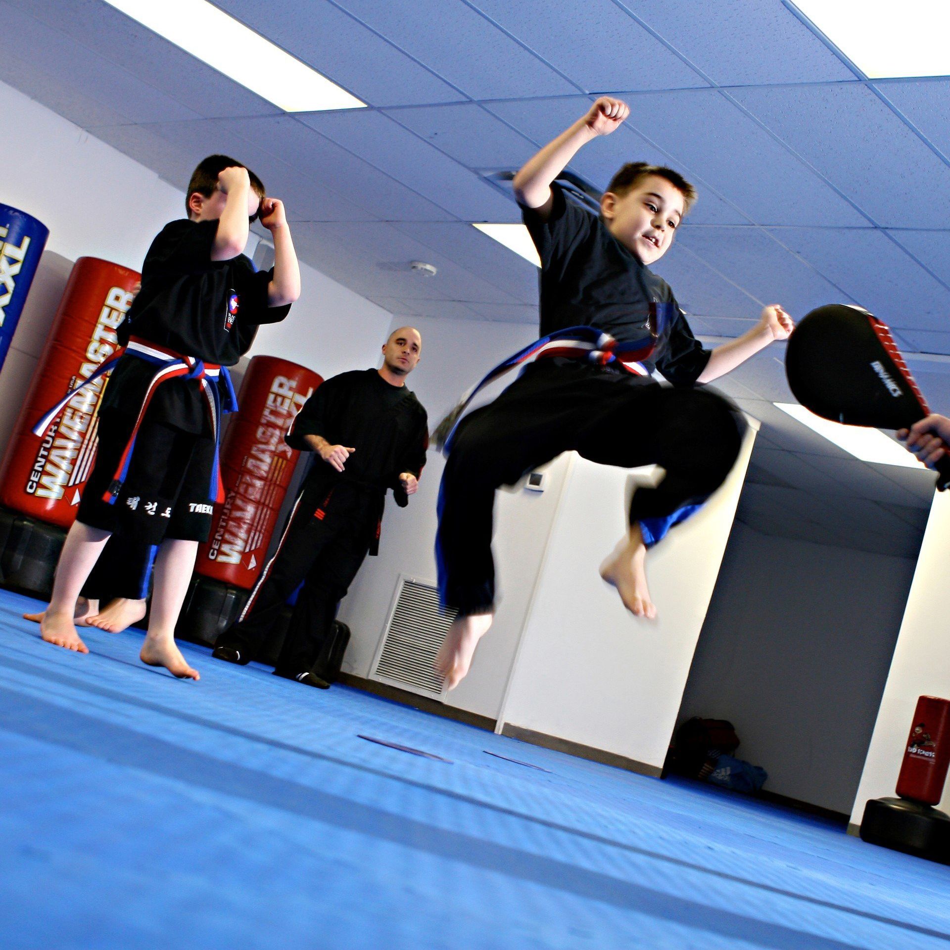 little kids jumping and kicking in martial arts