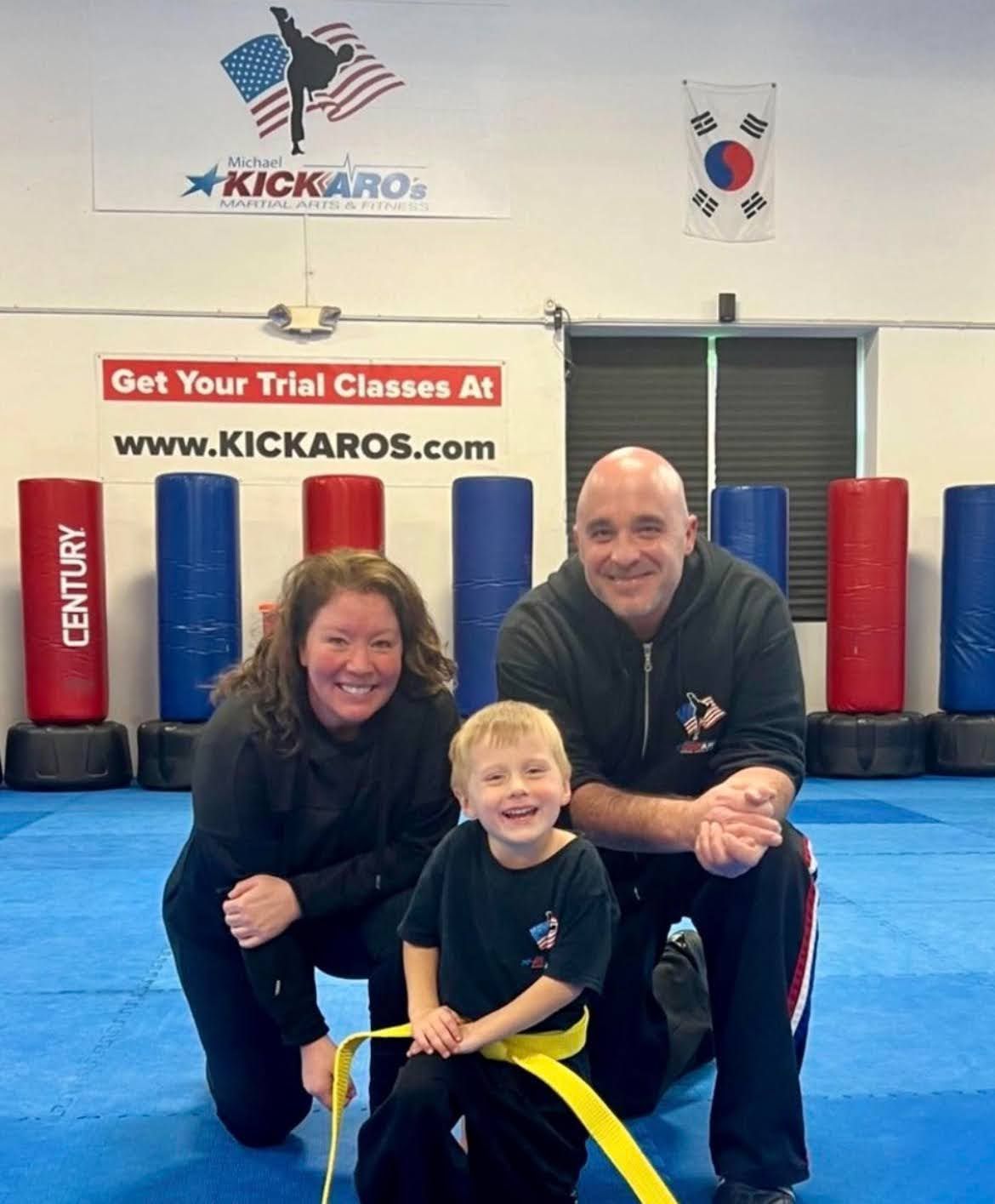 A young boy flexing his muscles in a gym