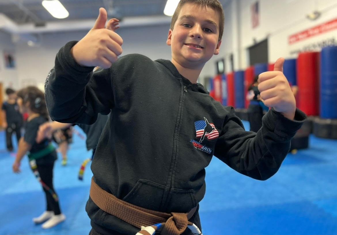 a young boy with a yellow belt in a gym