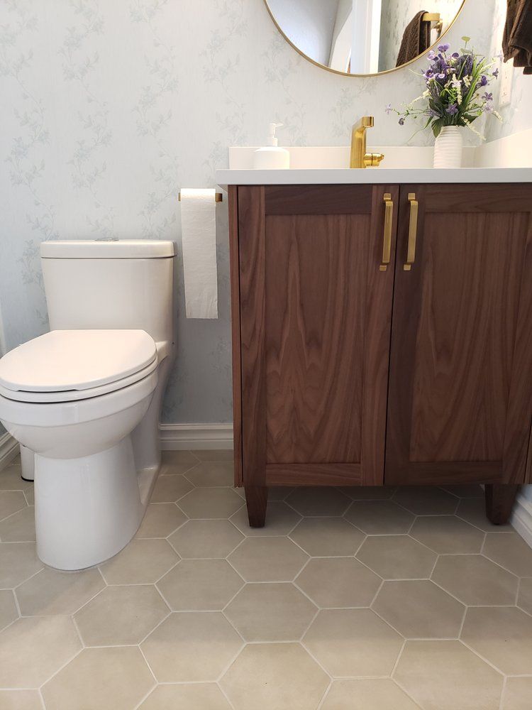Modern Sherwood Park bathroom with walnut vanity with, white toilet, and light grey hexagon floor tiles by XMP Construction.