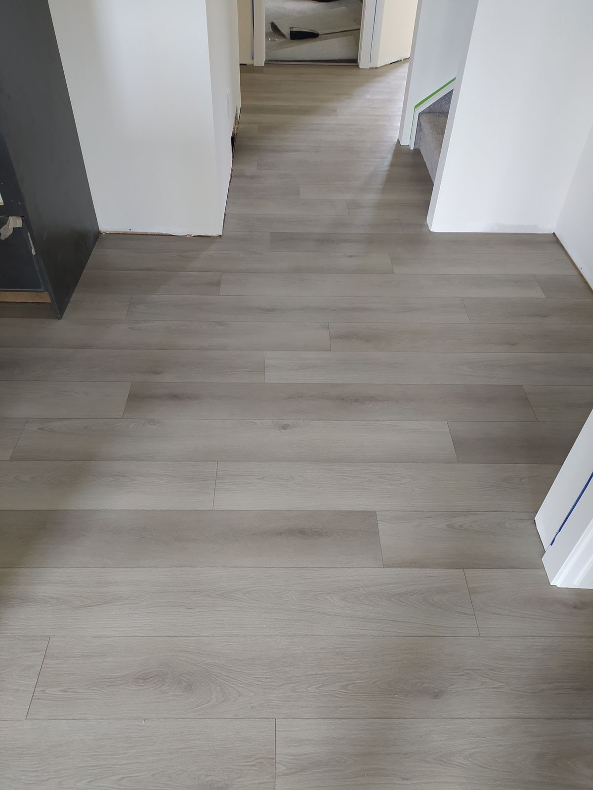 Light grey luxury vinyl plank flooring installed in a Sherwood Park hallway by XMP Construction.