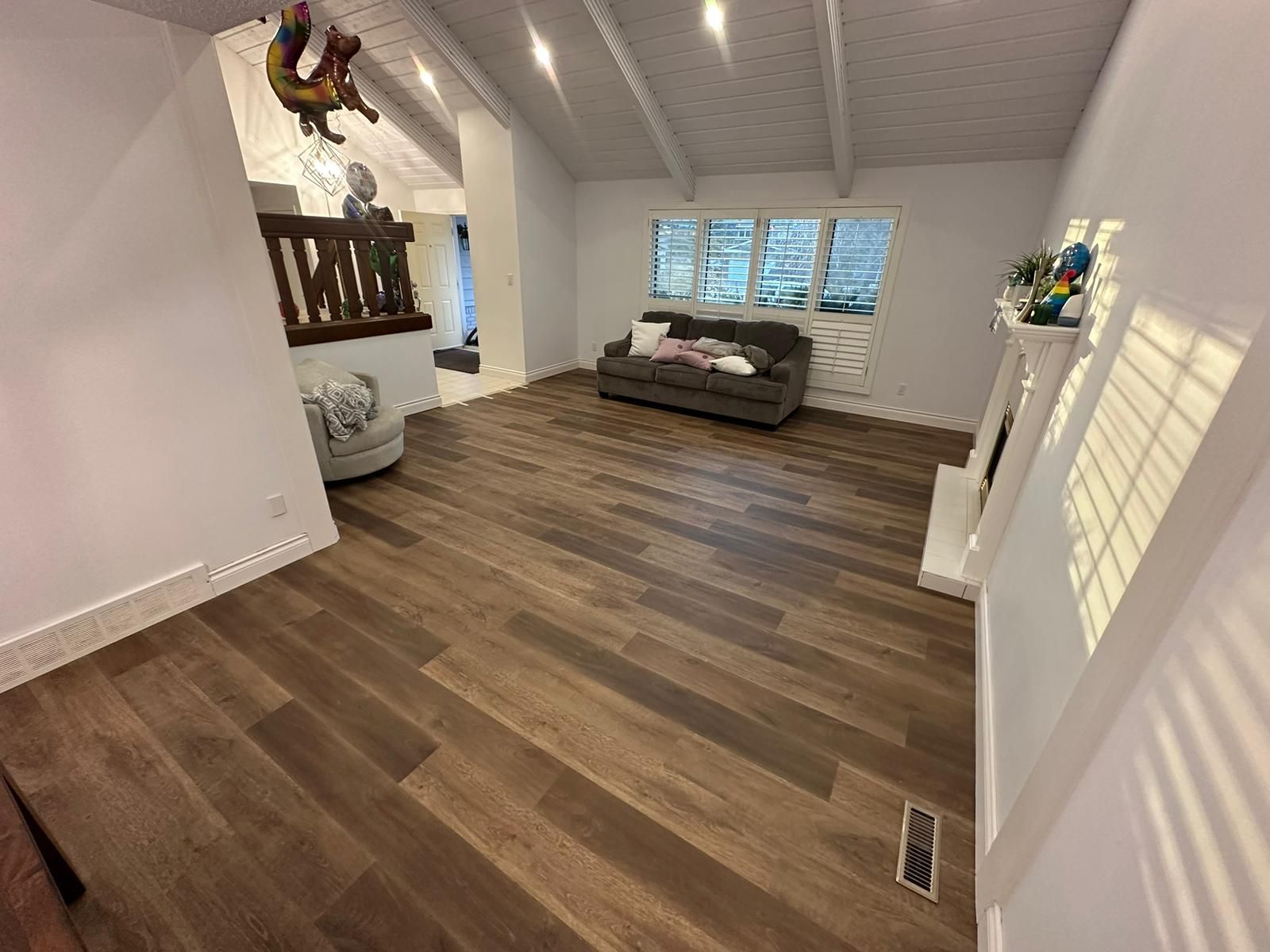Dark luxury vinyl plank flooring installed in a vaulted ceiling living room by XMP Construction in Sherwood Park.