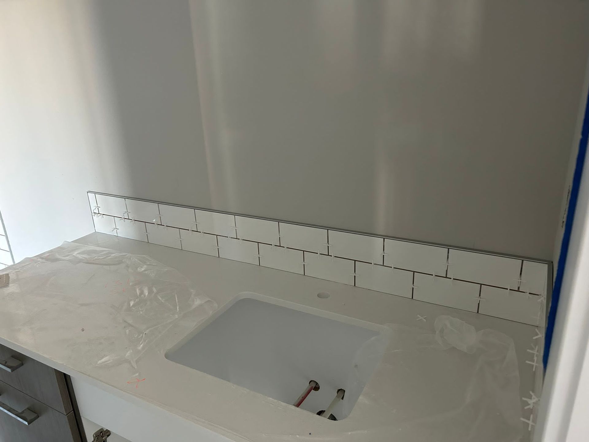Installation of white subway tiles as a backsplash in a Sherwood Park bathroom by XMP Construction.
