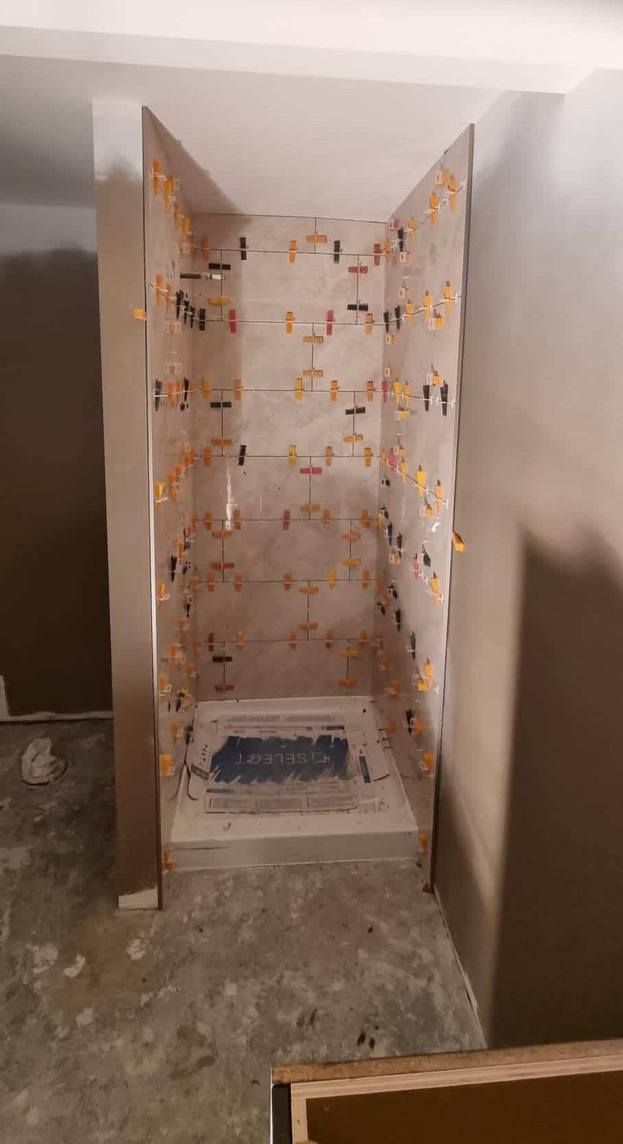 Installation of large light beige tiles in a Sherwood Park shower niche by XMP Construction.