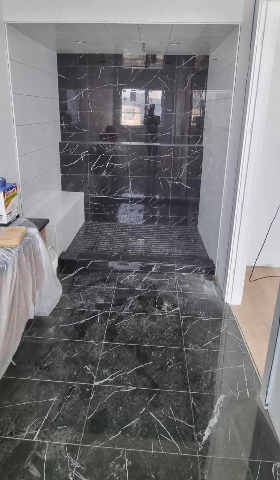 Modern Sherwood Park shower with striking black marble-look tiles and a linear drain by XMP Construction.
