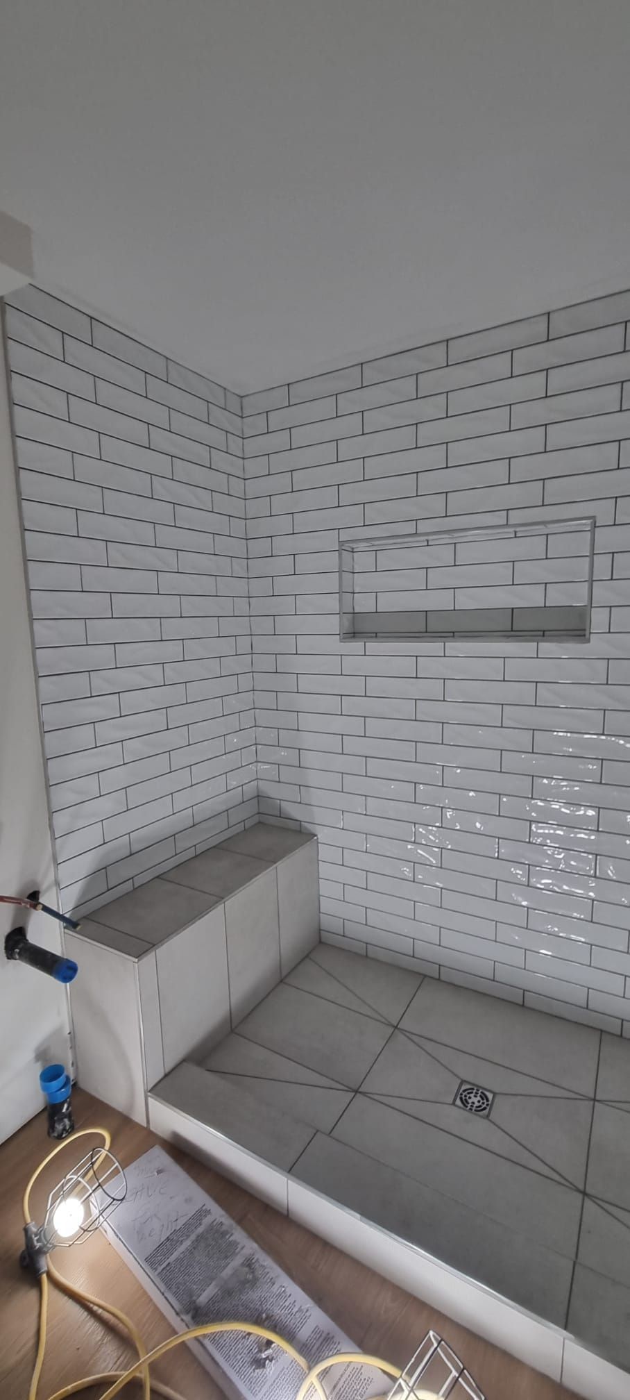 Bright Sherwood Park shower with classic white subway tiles and a built-in bench by XMP Construction.