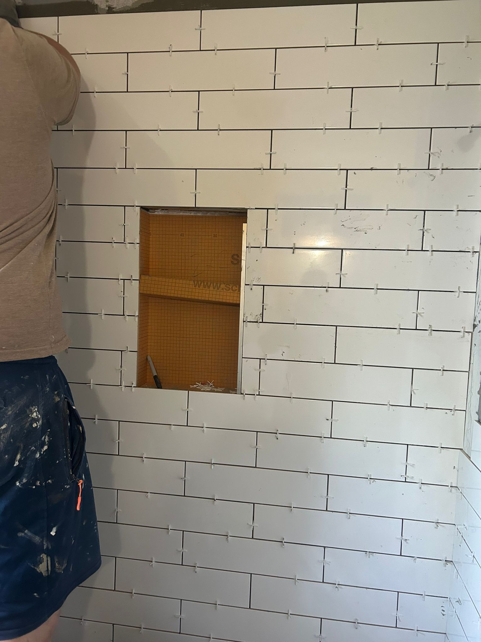Installation of classic white subway tiles with a niche in a Sherwood Park shower by XMP Construction.