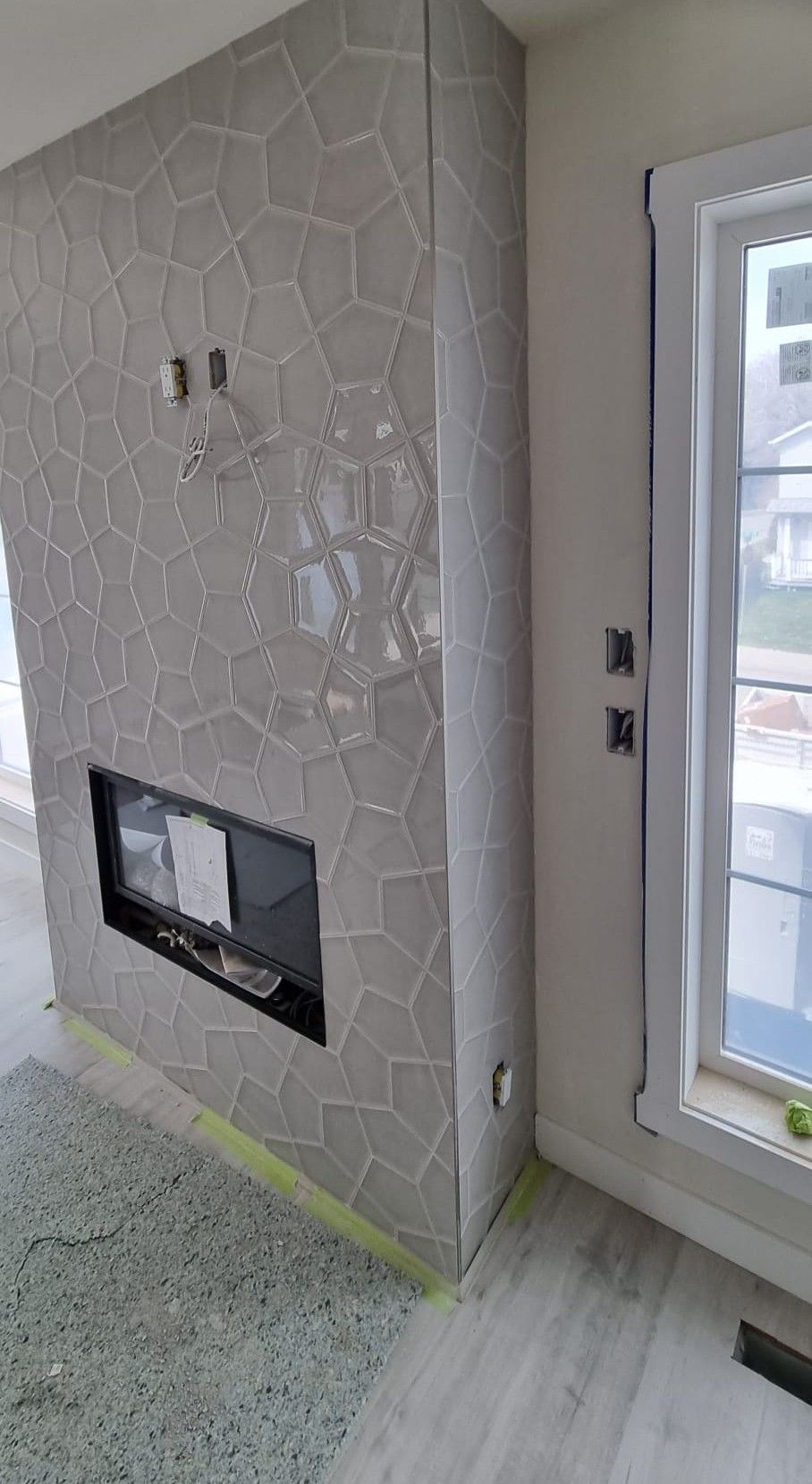 Modern Sherwood Park fireplace featuring unique grey geometric tiles by XMP Construction.