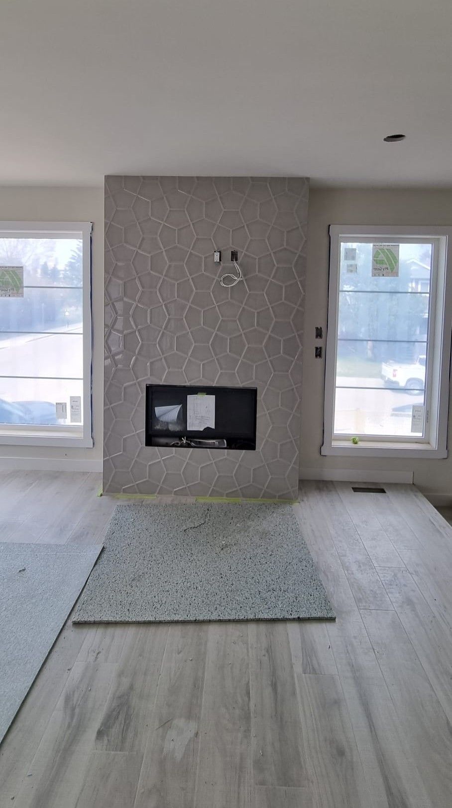 Modern Sherwood Park living room featuring a fireplace with unique grey geometric tiles by XMP Construction.