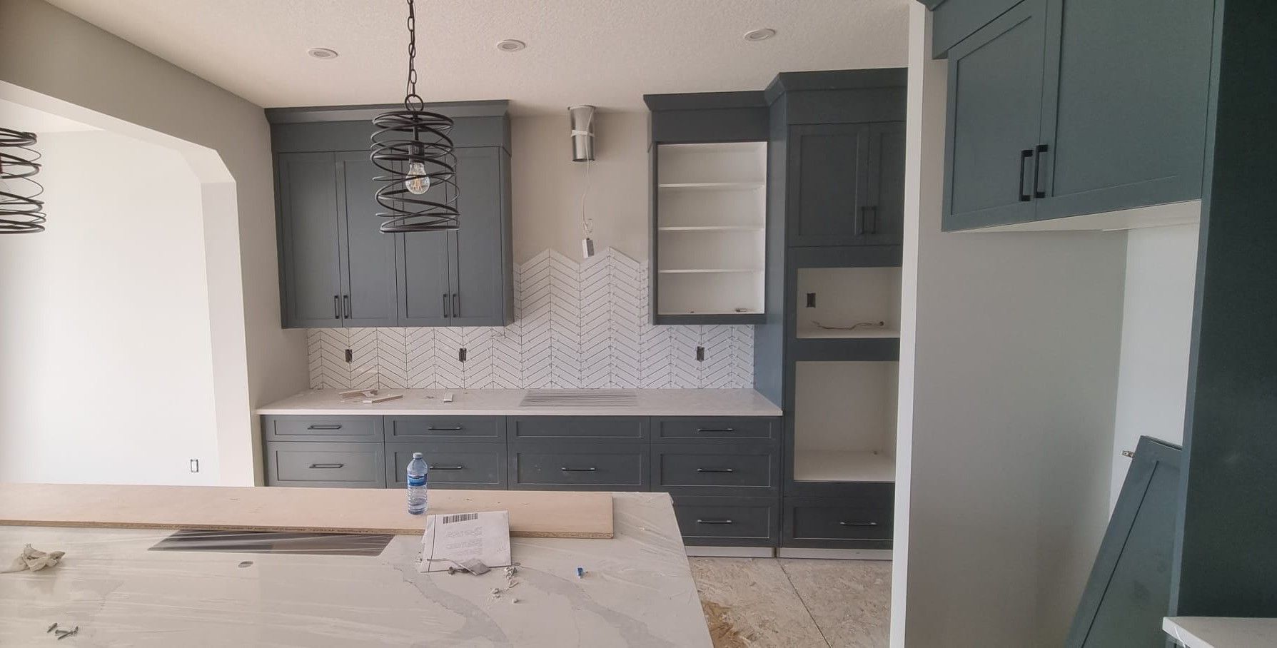 Modern Sherwood Park kitchen with stylish grey cabinetry and white herringbone backsplash by XMP Construction.