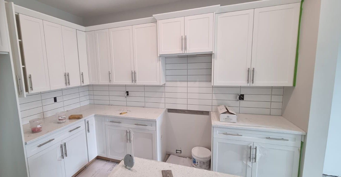 Bright Sherwood Park kitchen with white cabinets and a horizontal white subway tile backsplash by XMP Construction.